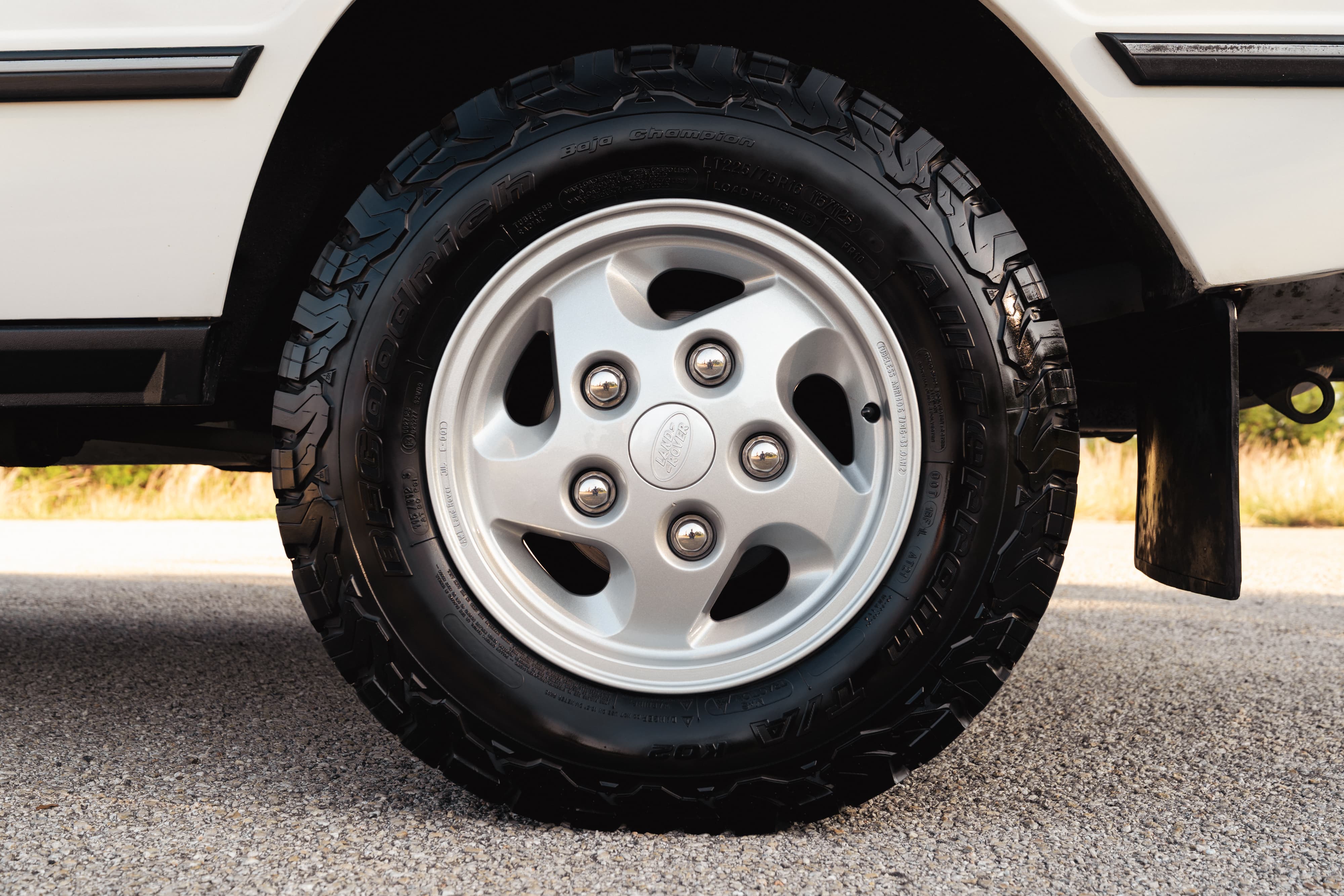 Close-up of a white 1995 Land Rover Range Rover County with silver five-spoke rims and rugged tires.