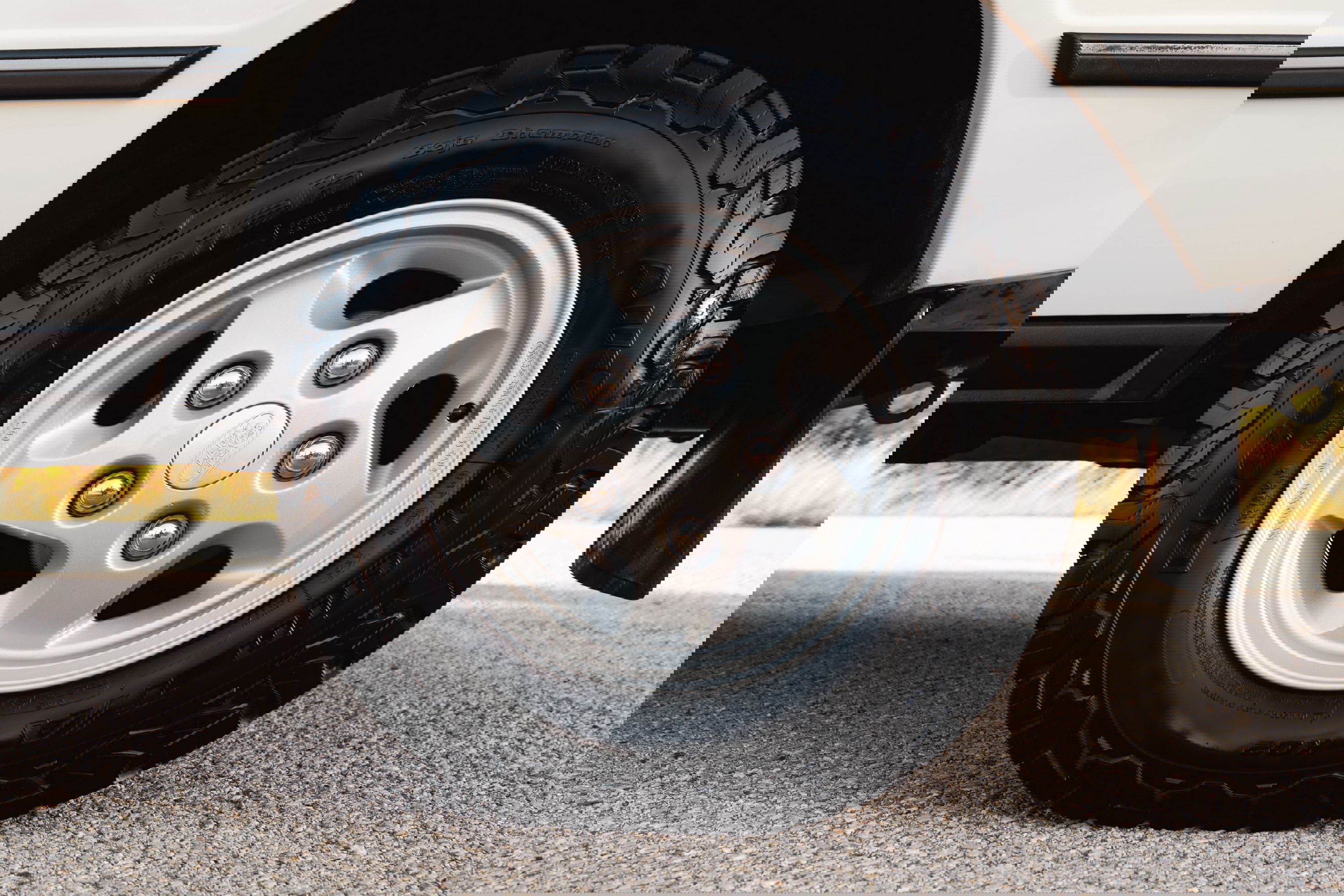Close-up of a white 1995 Land Rover Range Rover County with silver five-spoke rims and rugged tires.
