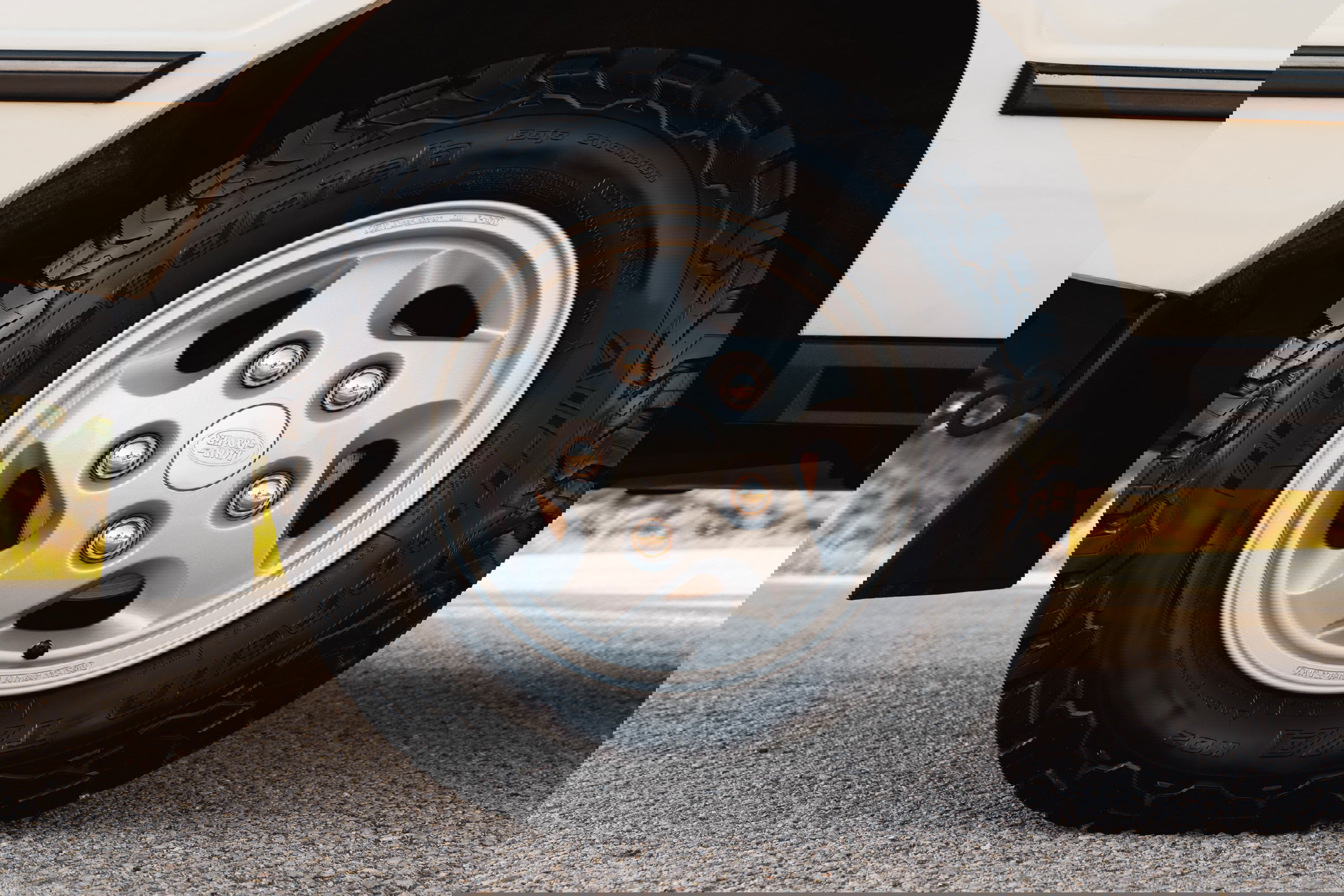 Close-up of a white 1995 Range Rover County's silver 5-spoke alloy rim with BFGoodrich tires.