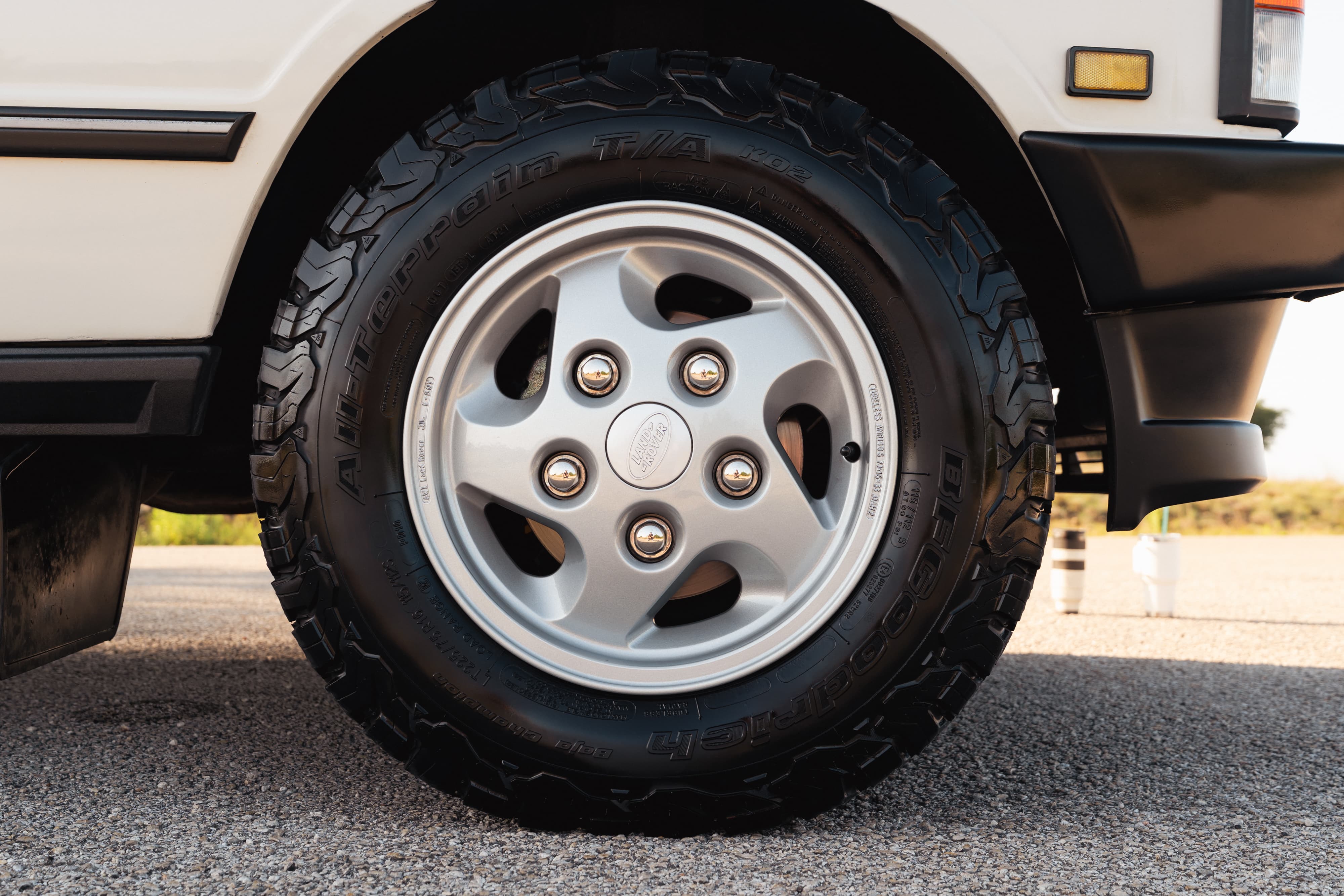 Close-up of a white 1995 Land Rover Range Rover County wheel with off-road tires.
