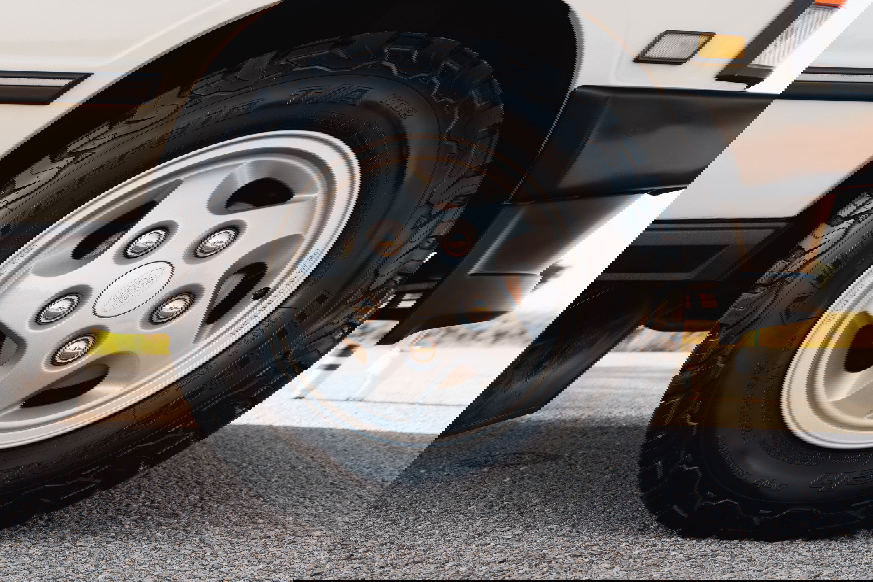 Close-up of a white 1995 Land Rover Range Rover County wheel with off-road tires.