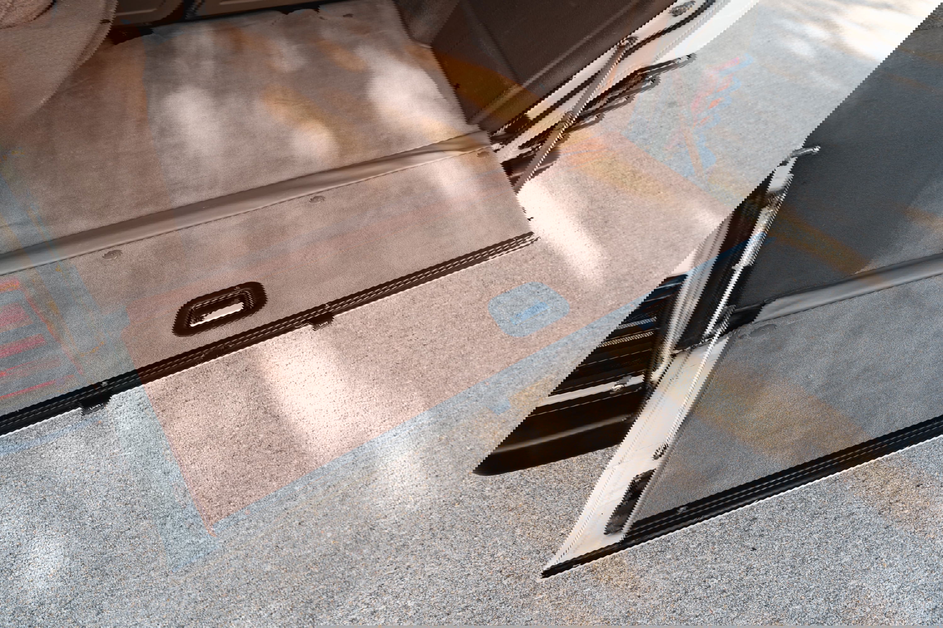 1995 Range Rover County cargo area with tan carpet and lowered tailgate.