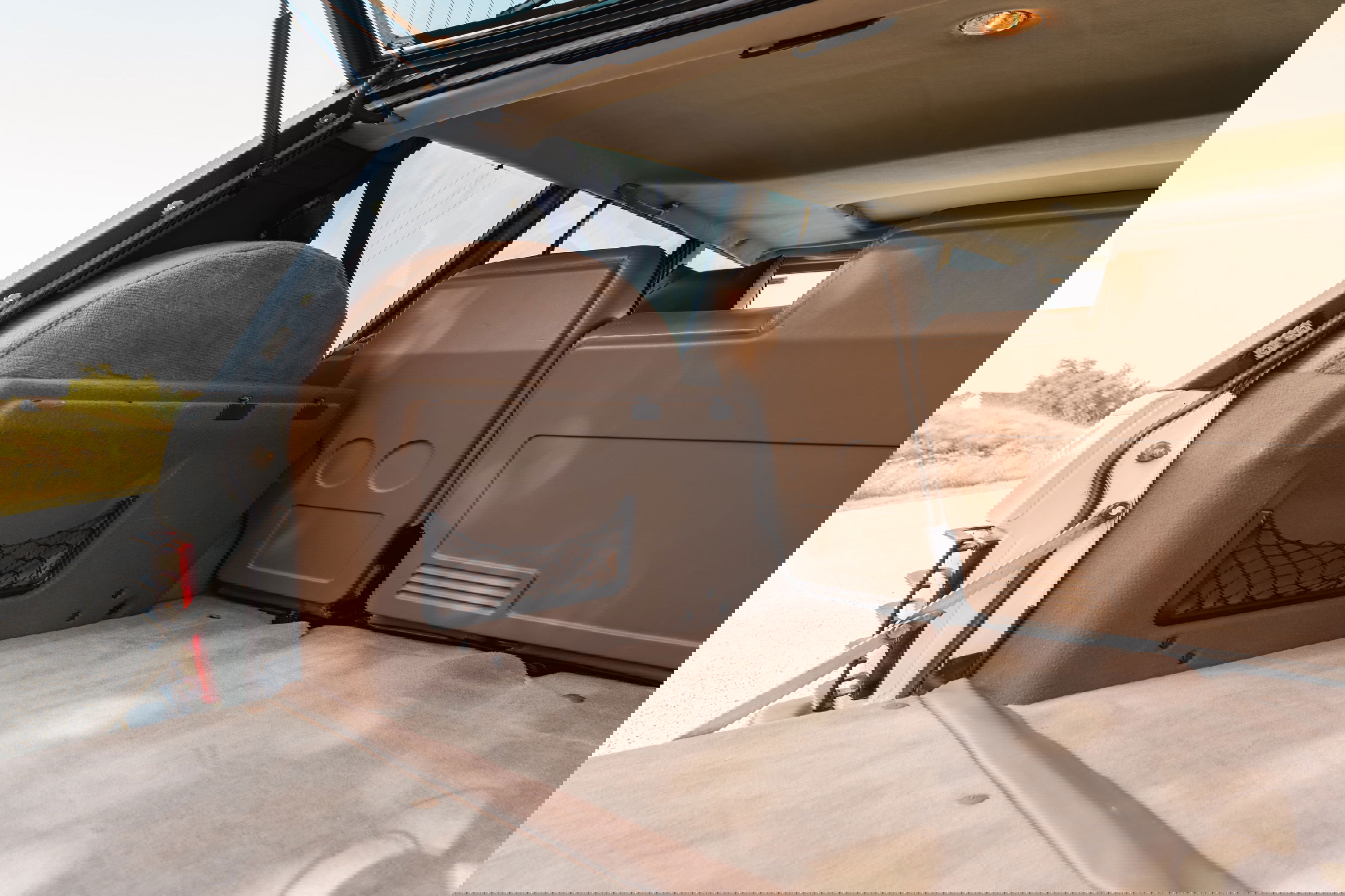 1995 Land Rover Range Rover County interior cargo area. Tan upholstery, carpeted floor, and spare tire cover.