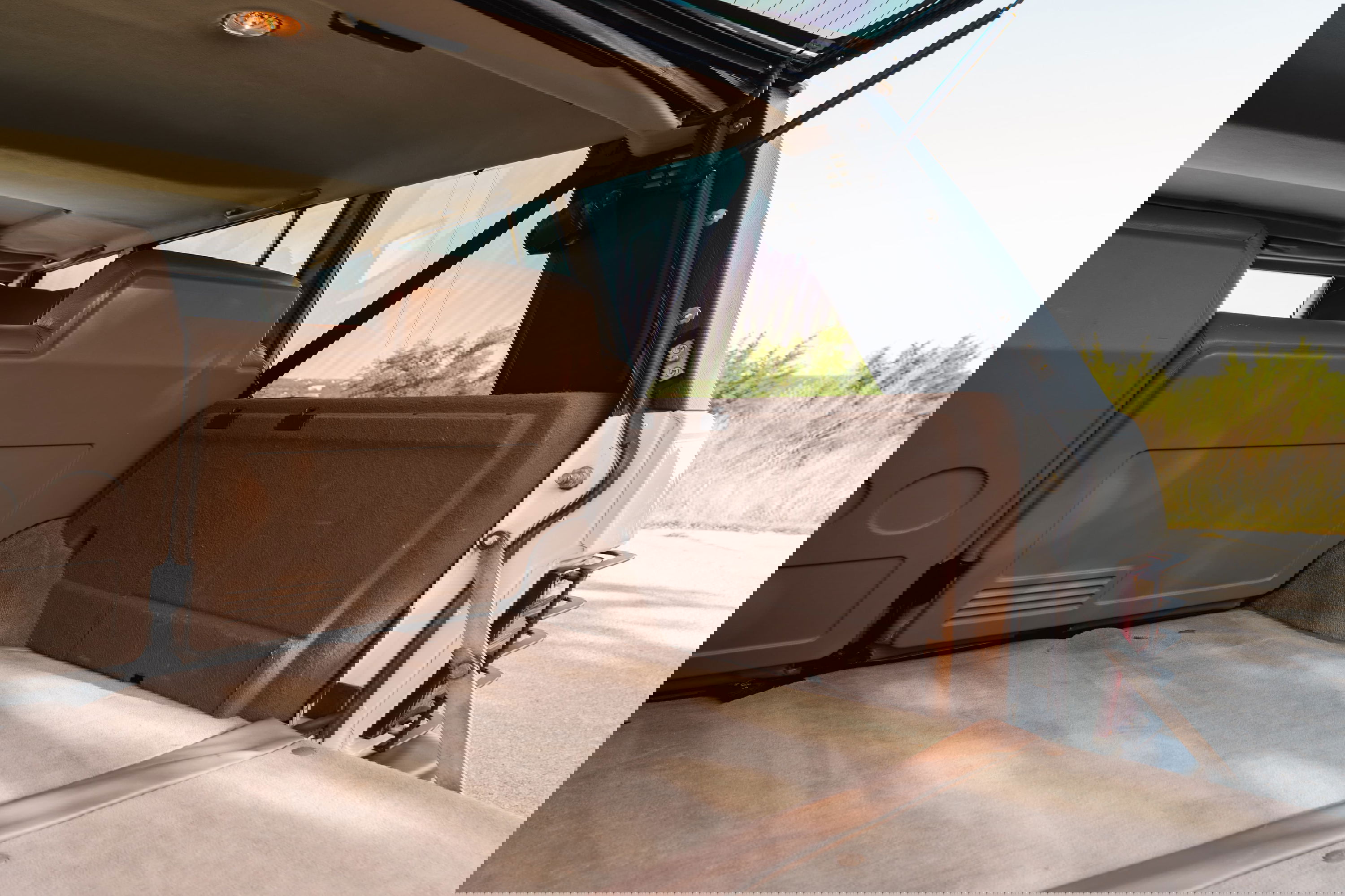 1995 Land Rover Range Rover County: tan carpeted cargo area with brown trim and open tailgate.