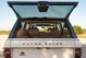 1995 Range Rover County rear hatch open, showing tan interior, chrome badge and trim.