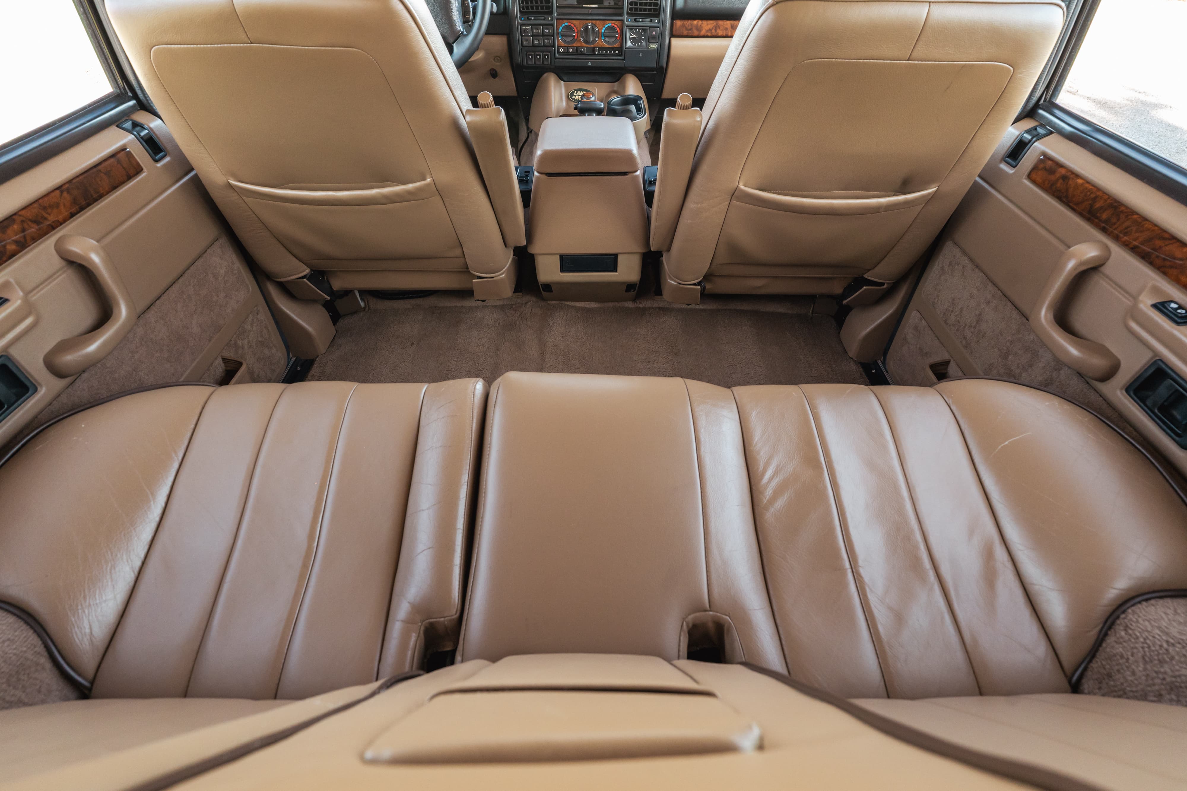 Interior view of a 1995 Land Rover Range Rover County's tan leather seats and wood trim.