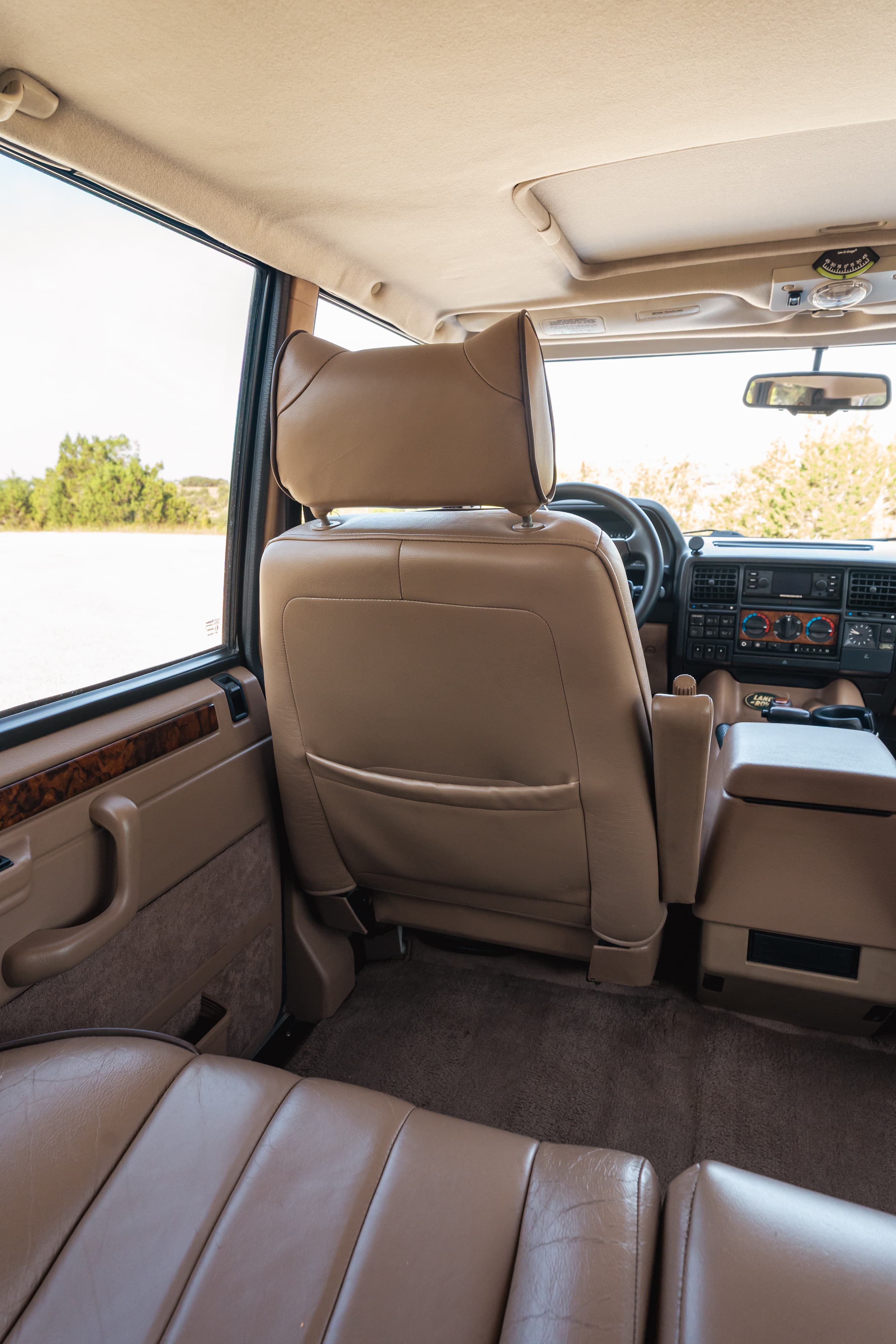 1995 Range Rover County interior. Tan leather seats, wood trim, sunroof, and dashboard details.