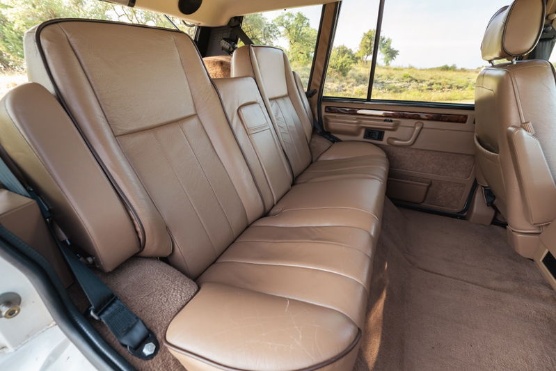 1995 Range Rover County interior: tan leather rear seats, wood trim, tan carpet.