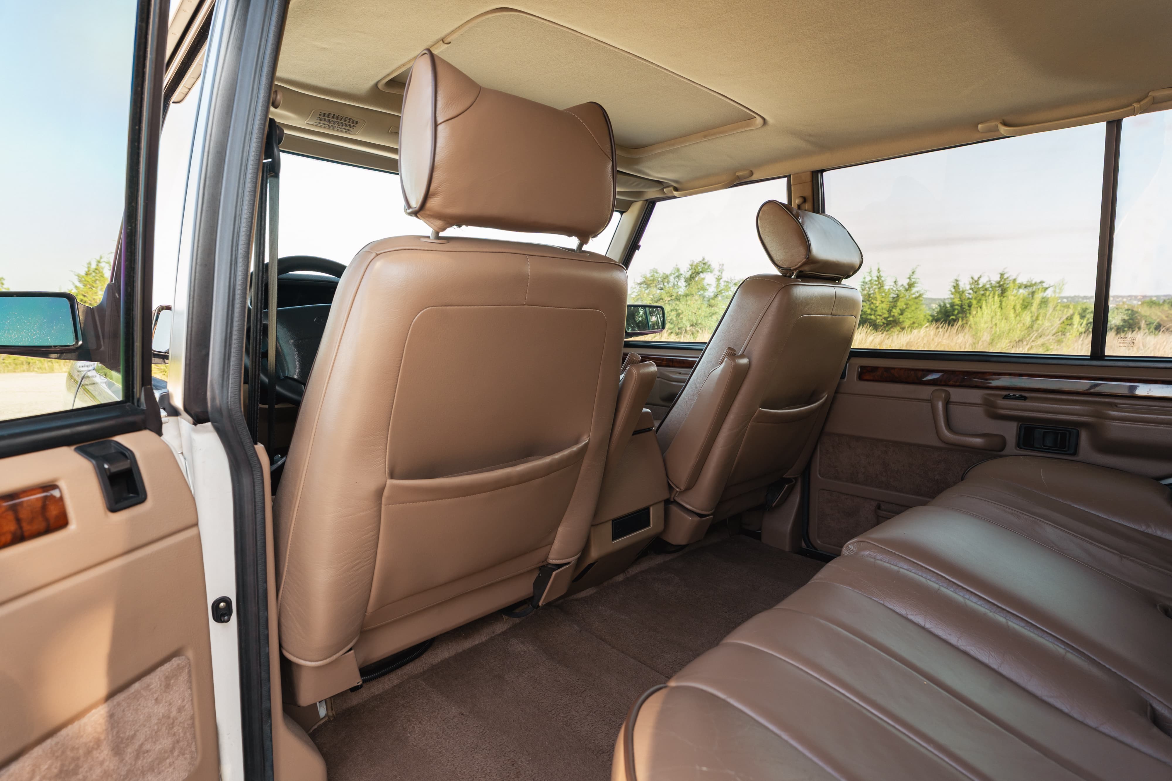 Interior of a white 1995 Land Rover Range Rover County, tan leather seats and trim.
