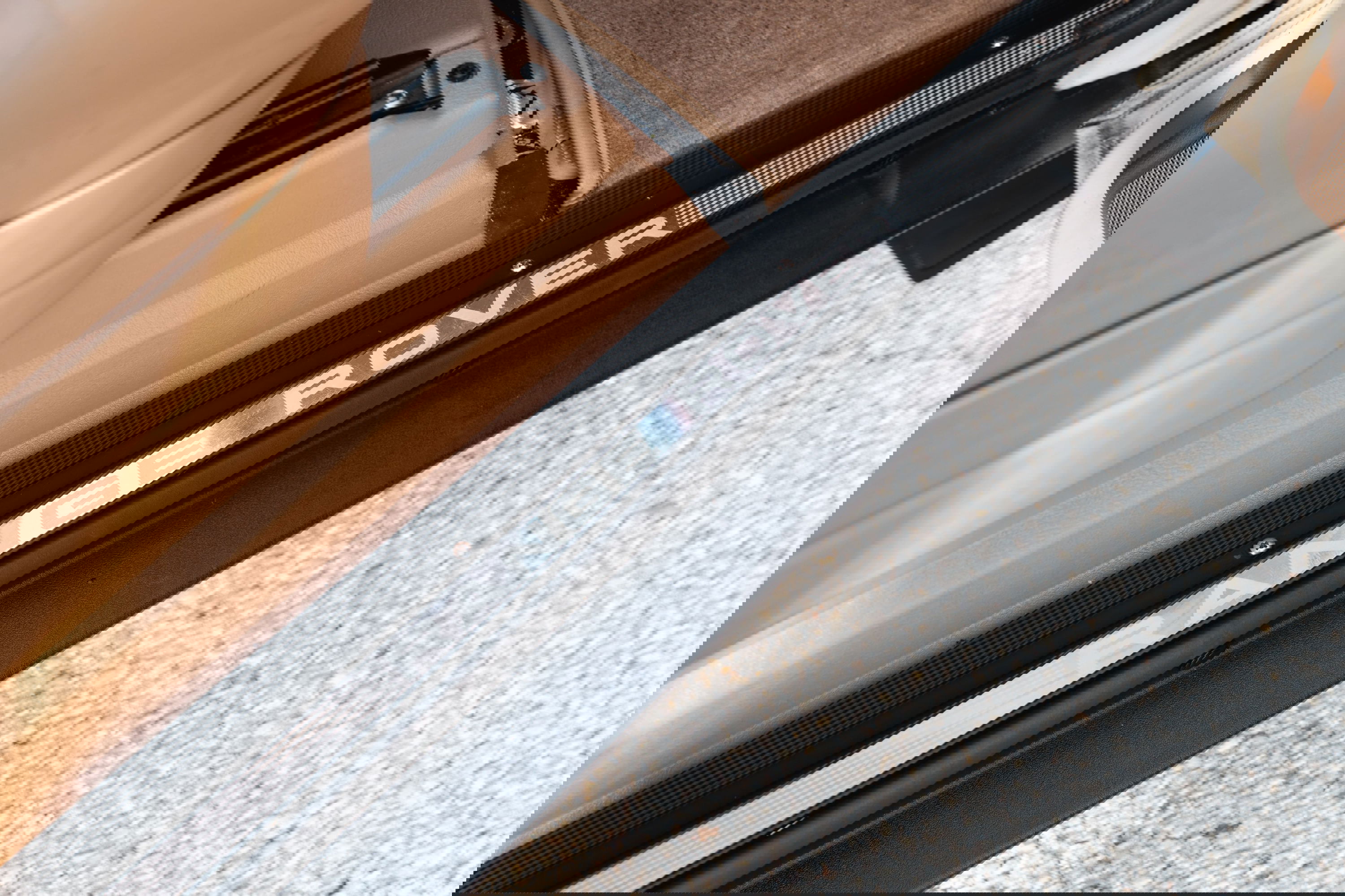 Close-up of the Range Rover lettering on the door sill trim of a white 1995 Land Rover Range Rover County.