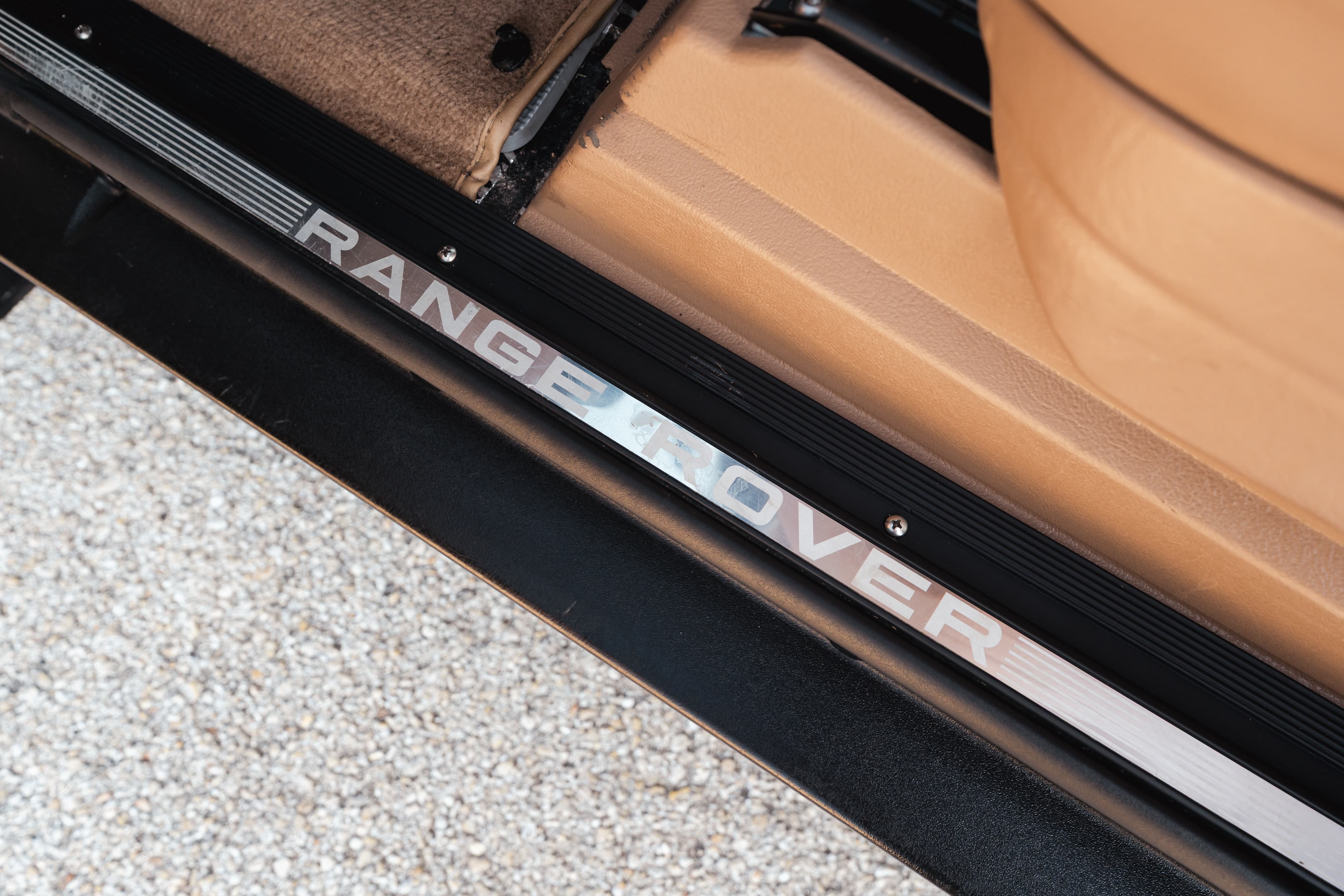 Close-up of a white 1995 Range Rover County door sill trim.