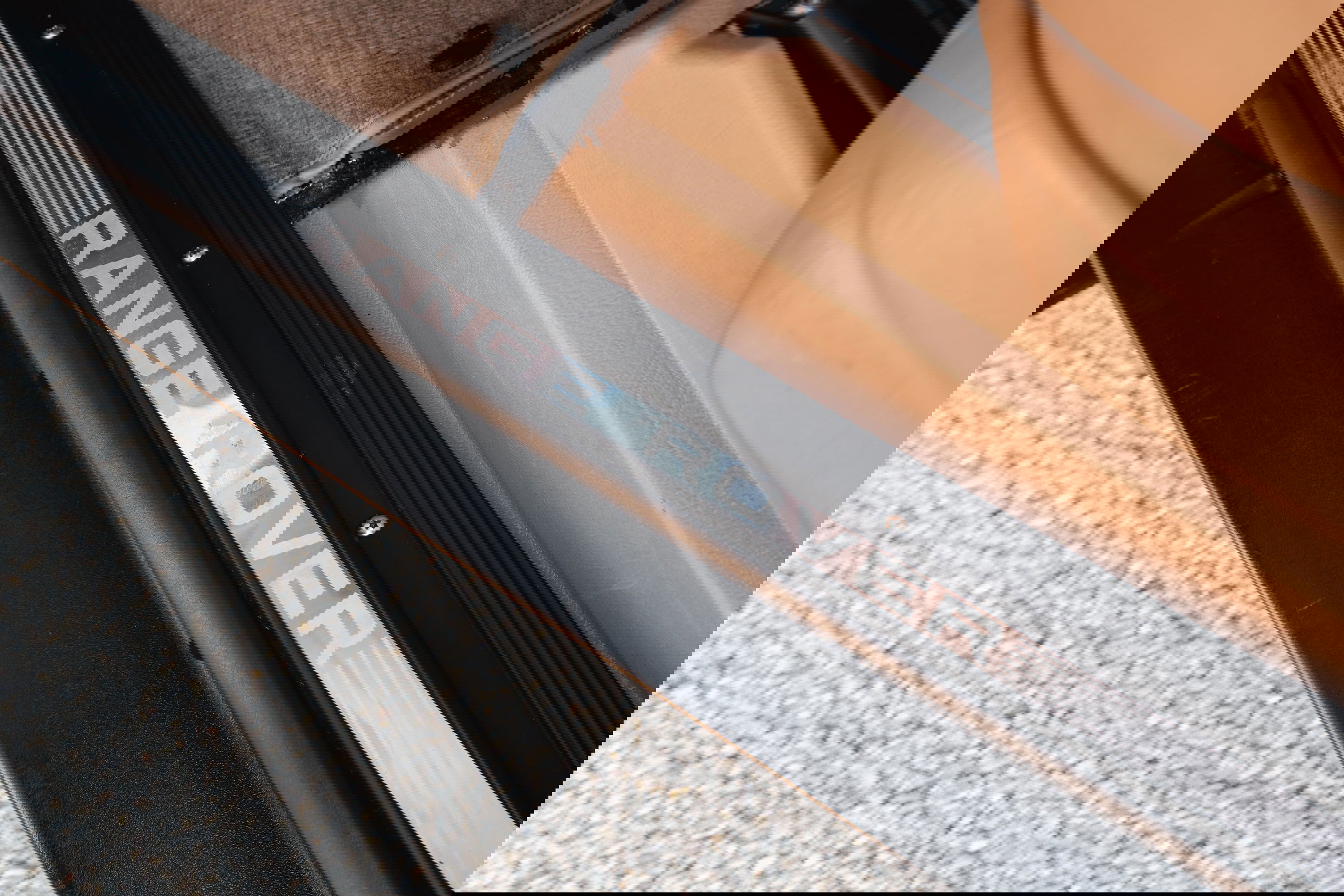 Close-up of a white 1995 Range Rover County door sill trim.