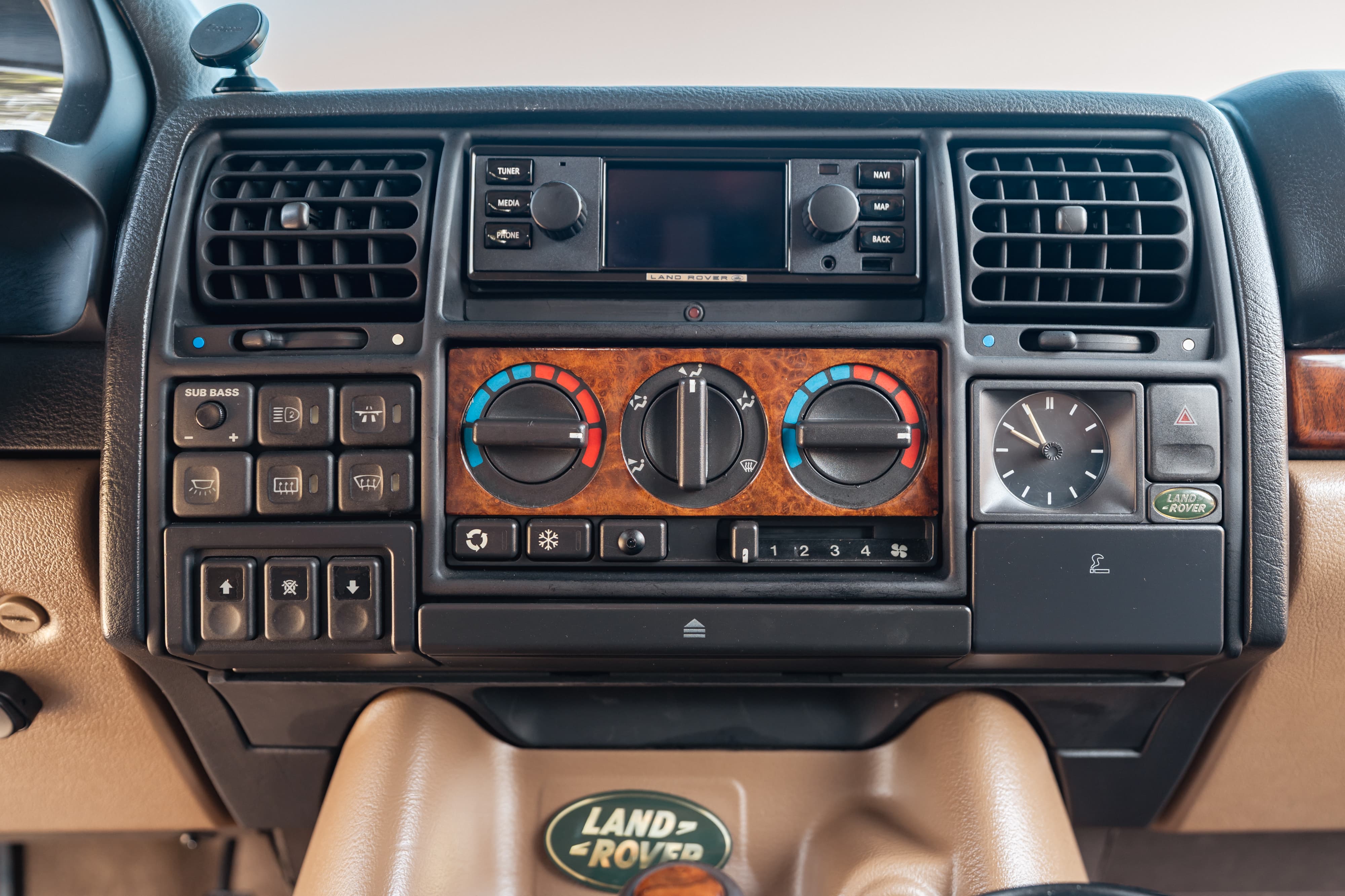 1995 white Range Rover County dash with wood trim, clock, and Land Rover badge.
