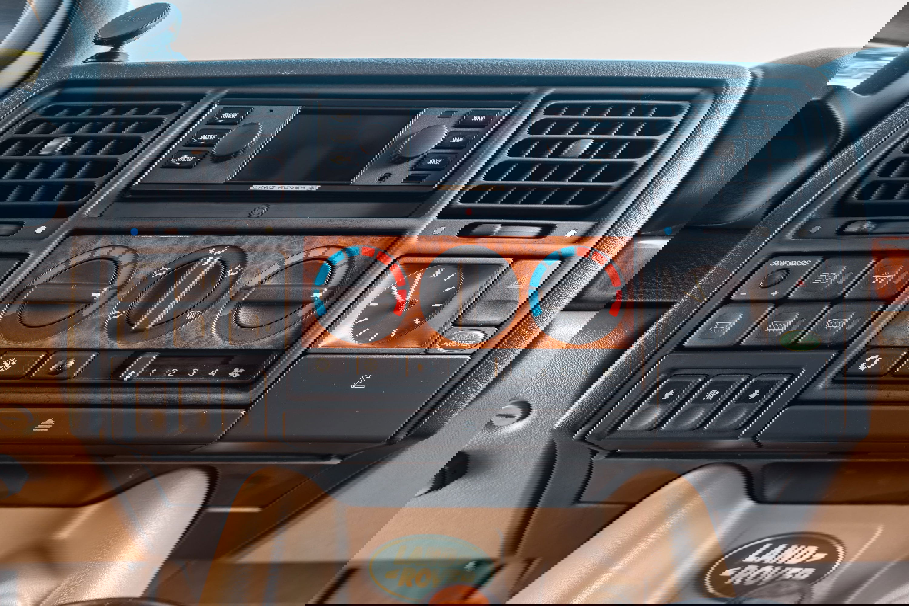 1995 white Range Rover County dash with wood trim, clock, and Land Rover badge.