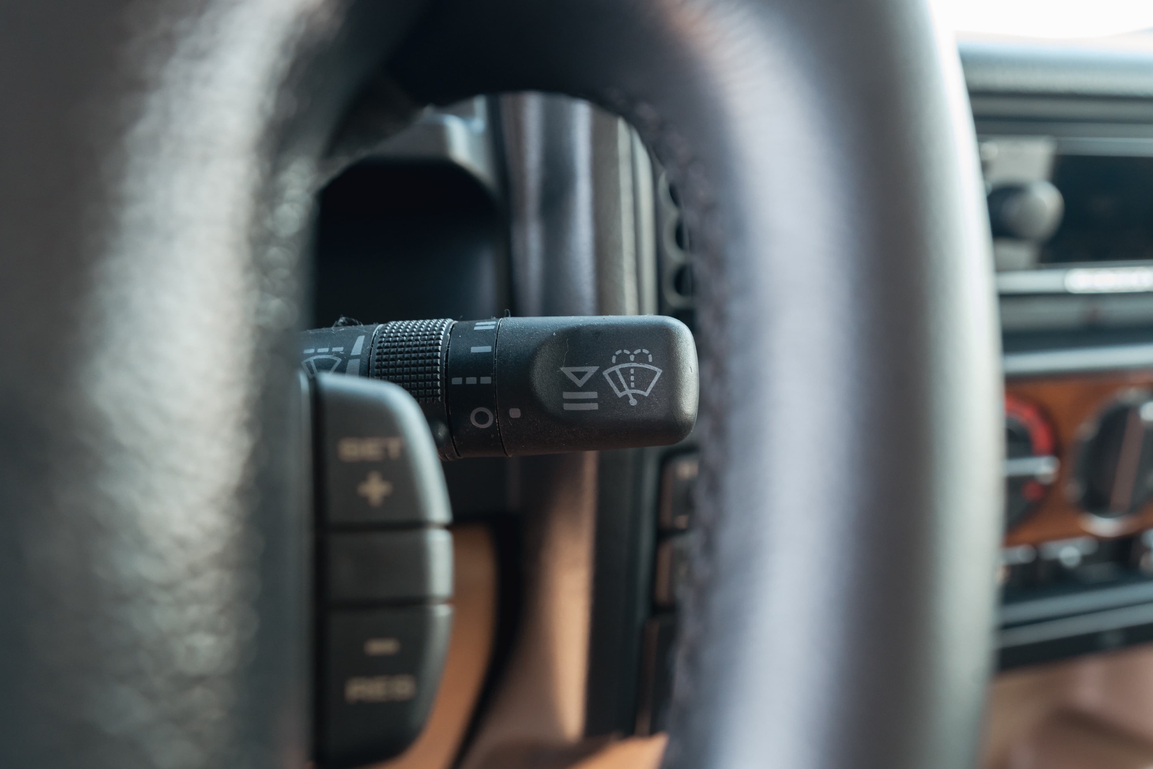 1995 white Land Rover Range Rover County steering wheel with wiper controls and cruise control buttons.