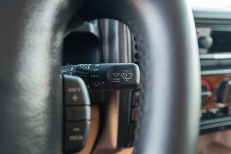 1995 white Land Rover Range Rover County steering wheel with wiper controls and cruise control buttons.