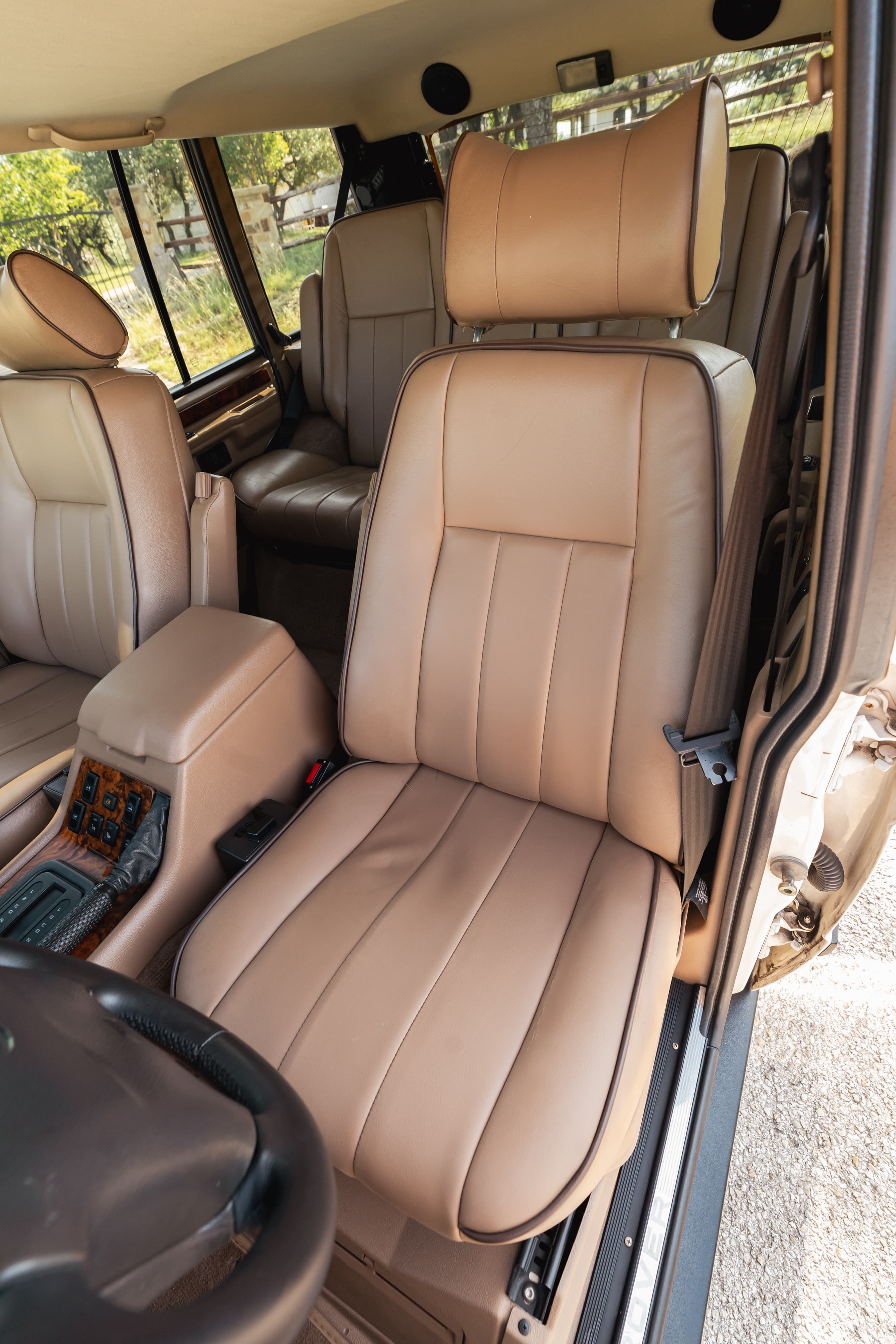 1995 Range Rover County interior with tan leather seats, wood trim, and automatic gear selector.