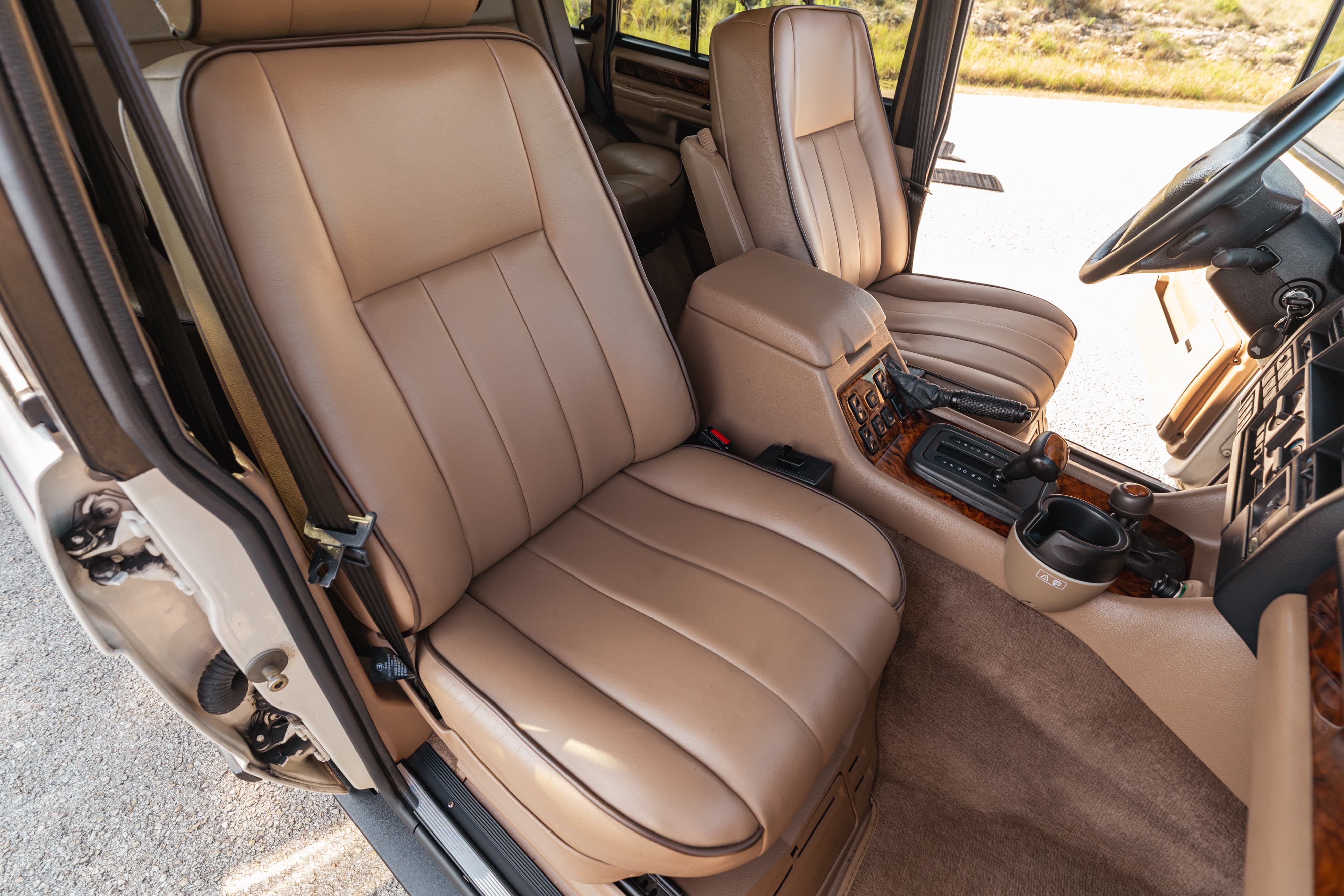 1995 white Land Rover Range Rover County interior. Tan leather seats, wood trim, center console.