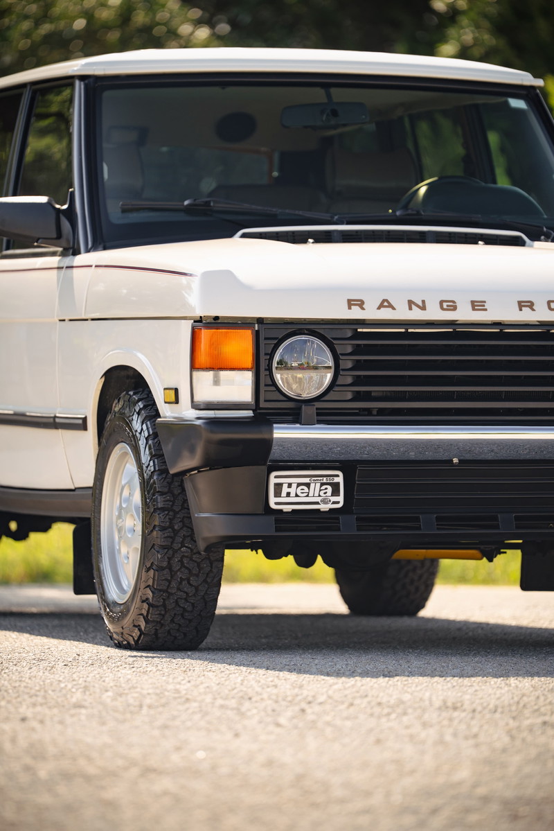 White 1995 Range Rover County front grille with Hella badge and chrome rims.
