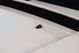 Black windshield washer nozzle on the hood of a white 1995 Land Rover Range Rover County.