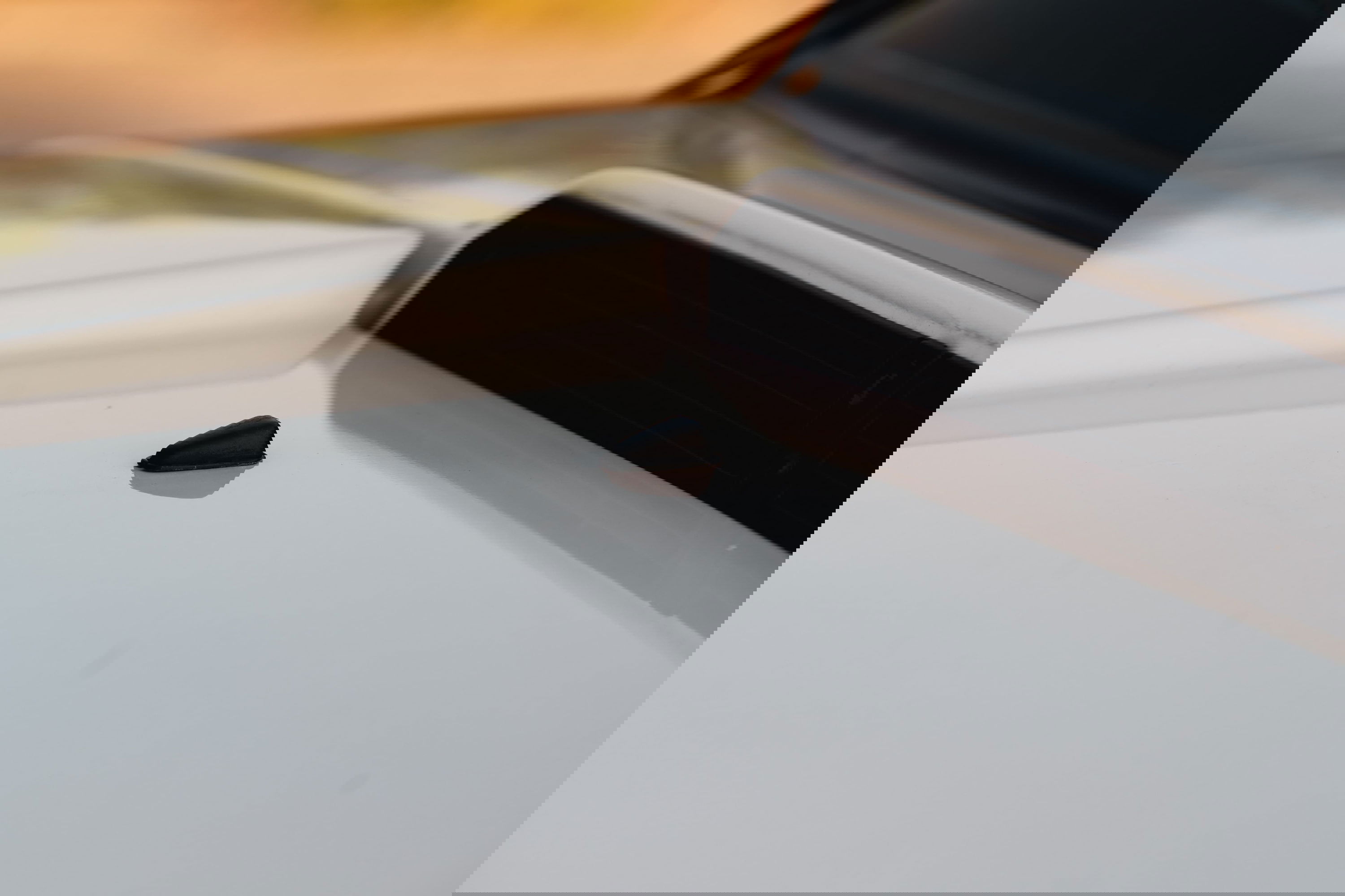 Close-up of a black shark fin antenna on the white roof of a 1995 Land Rover Range Rover County.