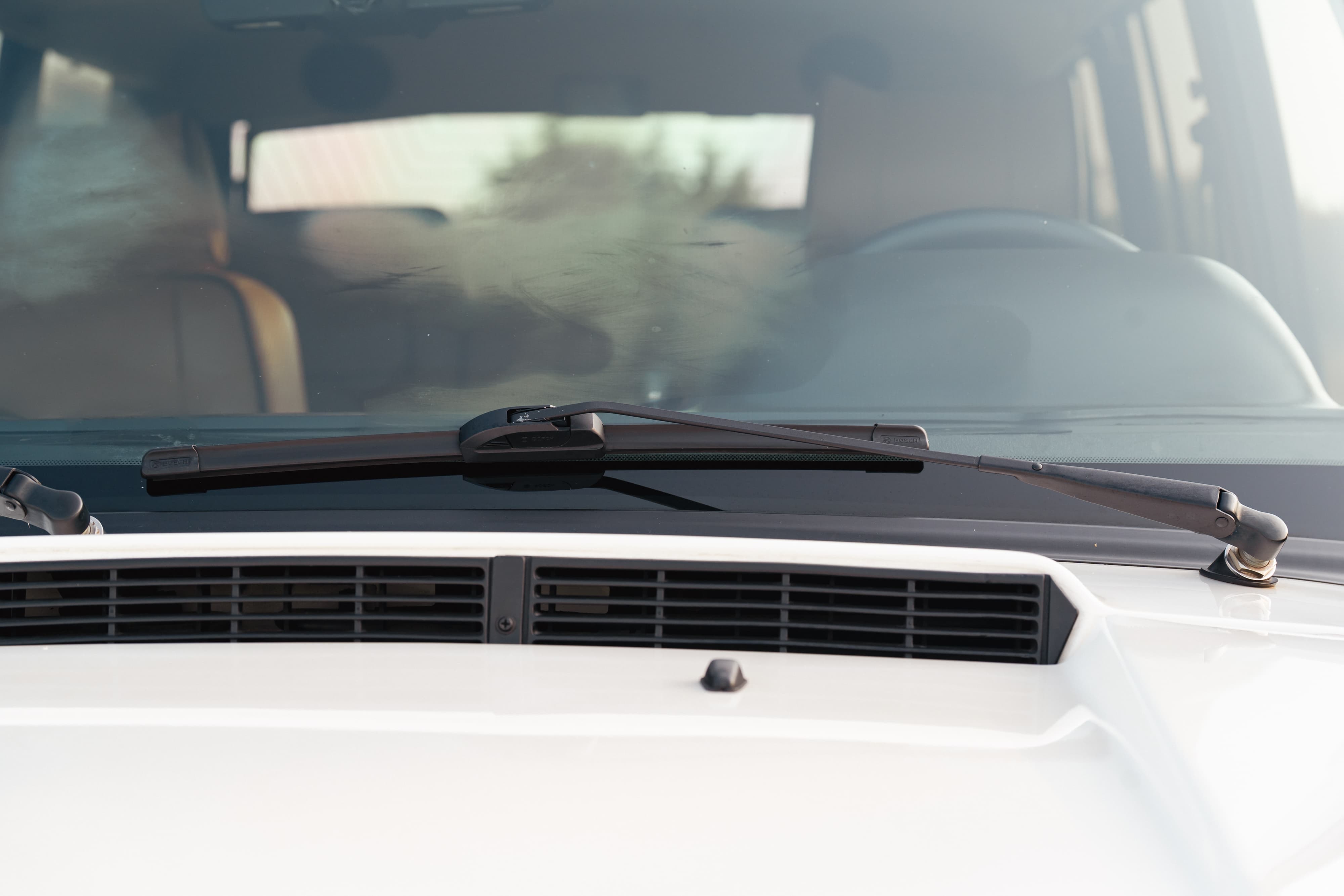 1995 white Land Rover Range Rover County windshield with wiper arm and hood vent.