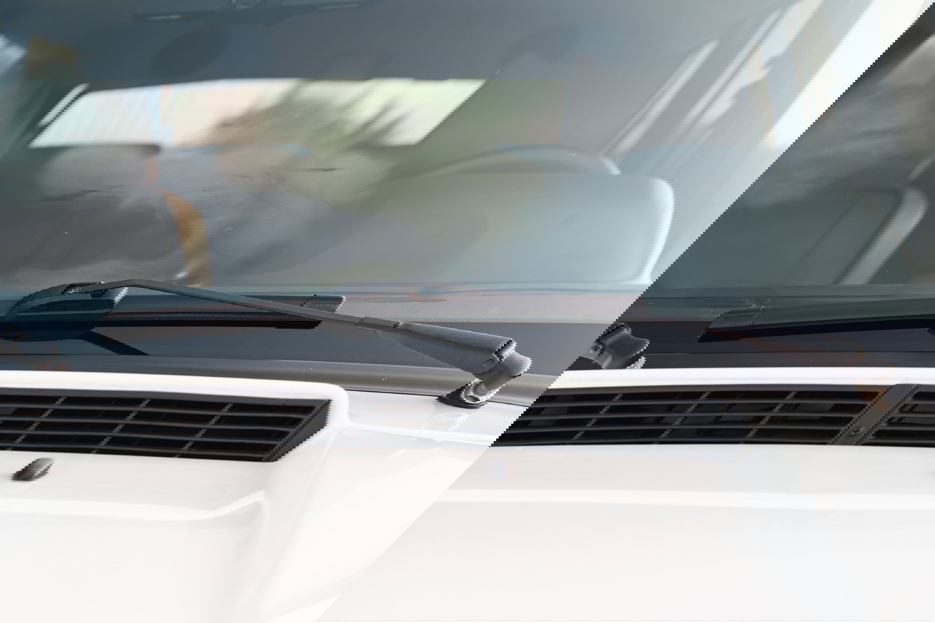 1995 white Land Rover Range Rover County windshield with wiper arm and hood vent.