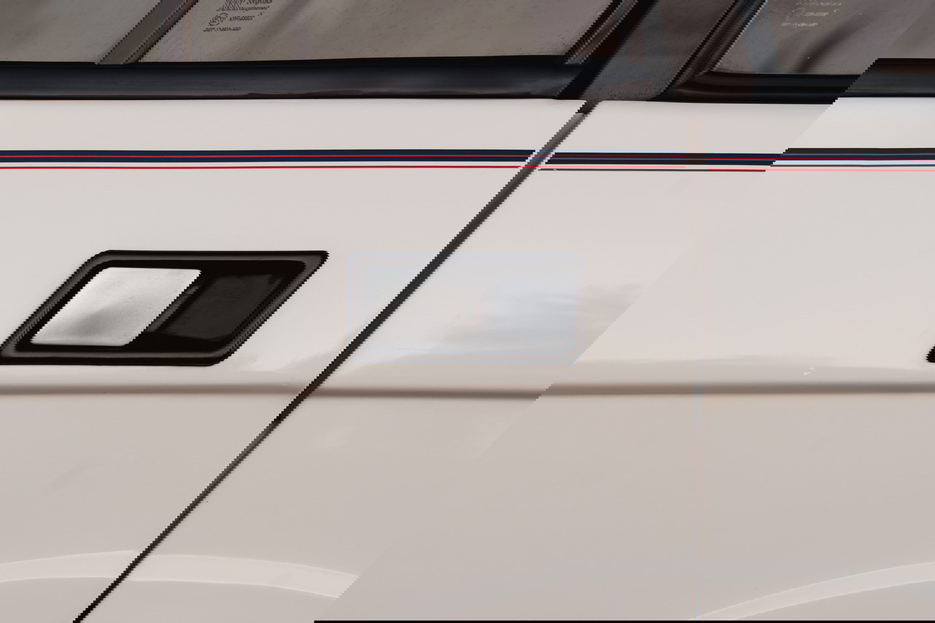 White 1995 Range Rover County with red and blue stripe livery, black and chrome door handle detail.
