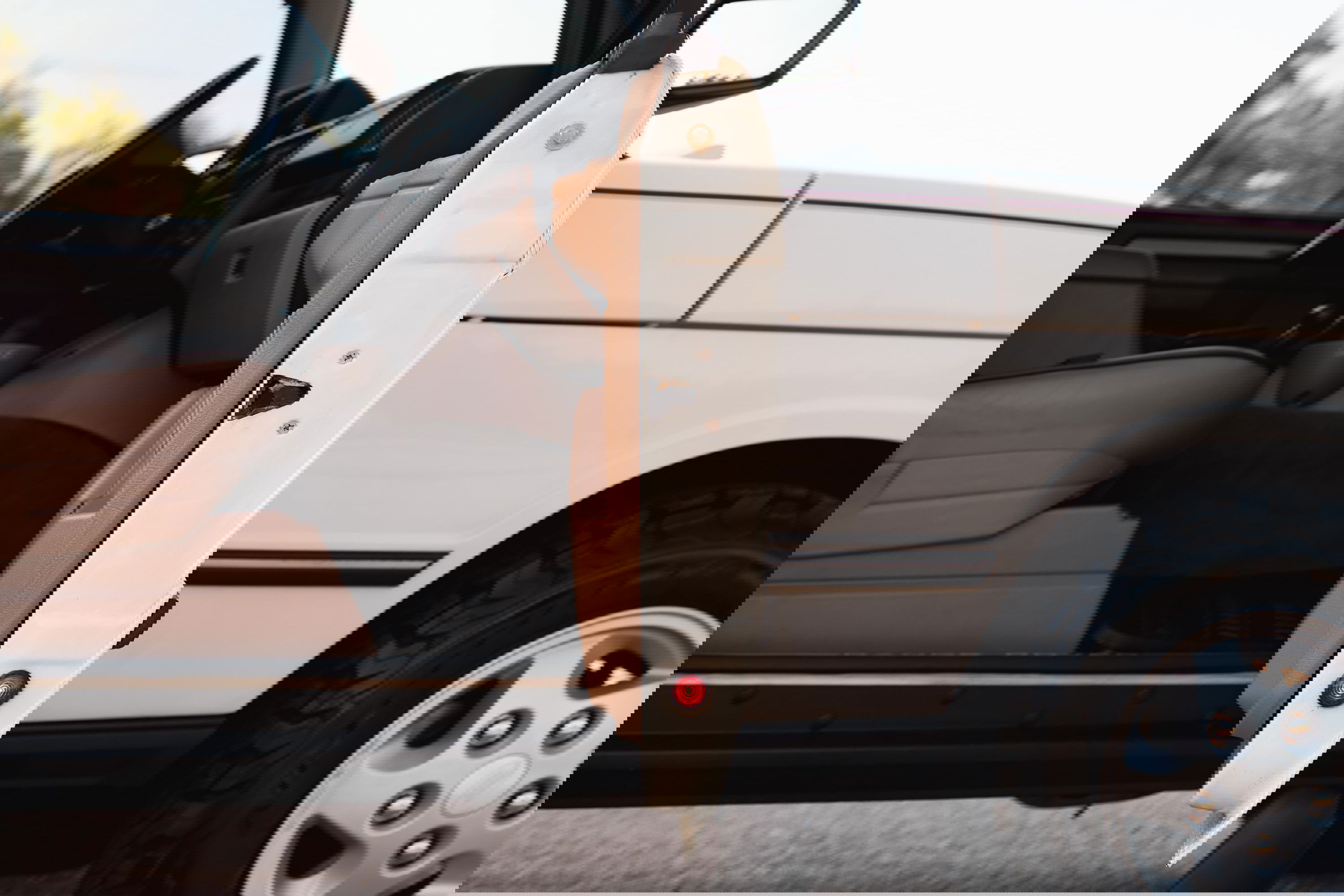 White 1995 Range Rover County with open driver door, tan interior, and alloy rims.