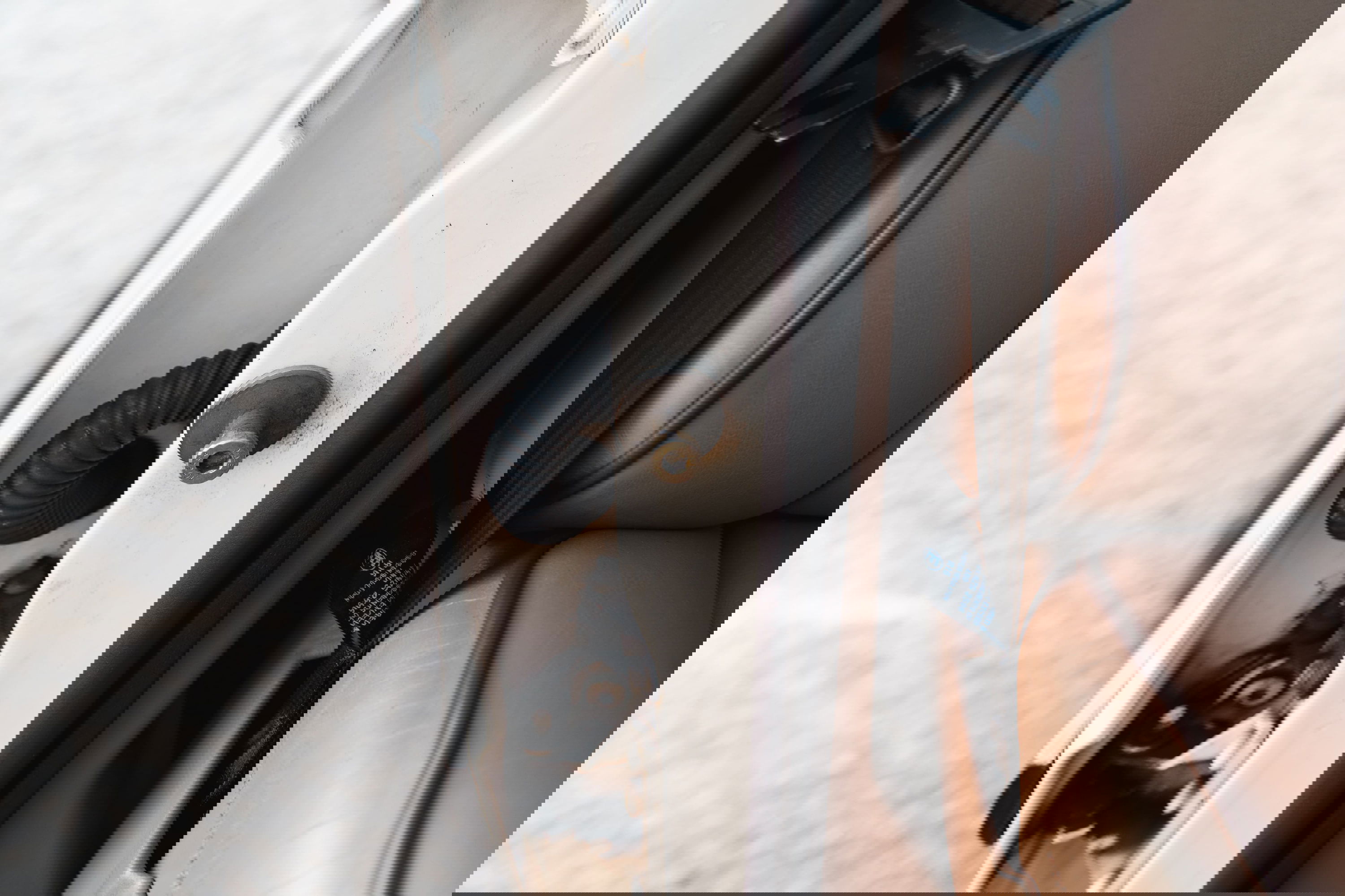 1995 white Range Rover County door jamb with beige leather seat and seatbelt.