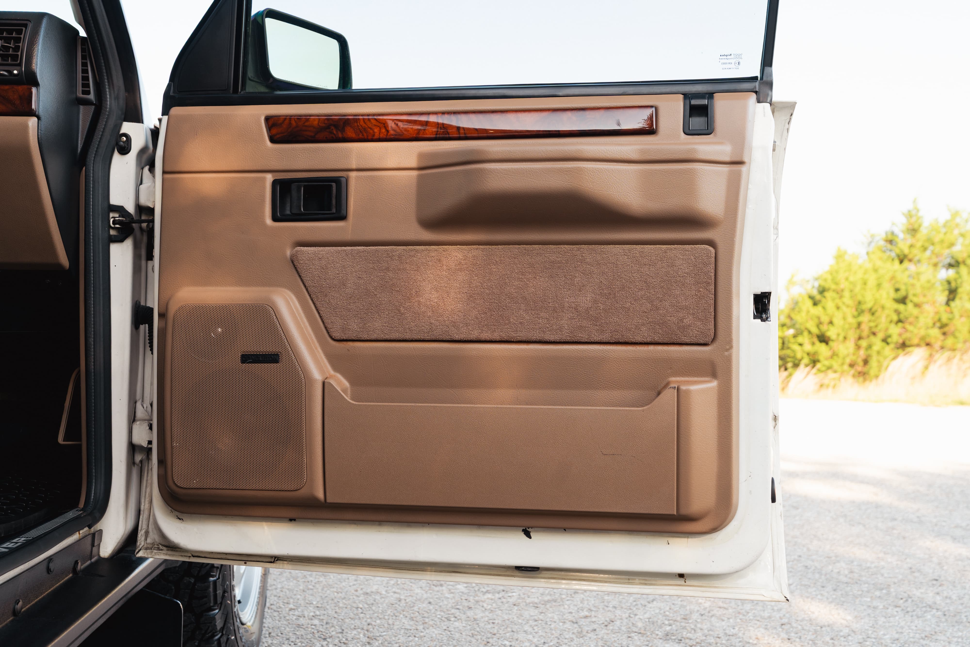 1995 white Range Rover County door panel with wood trim and Bose speaker.