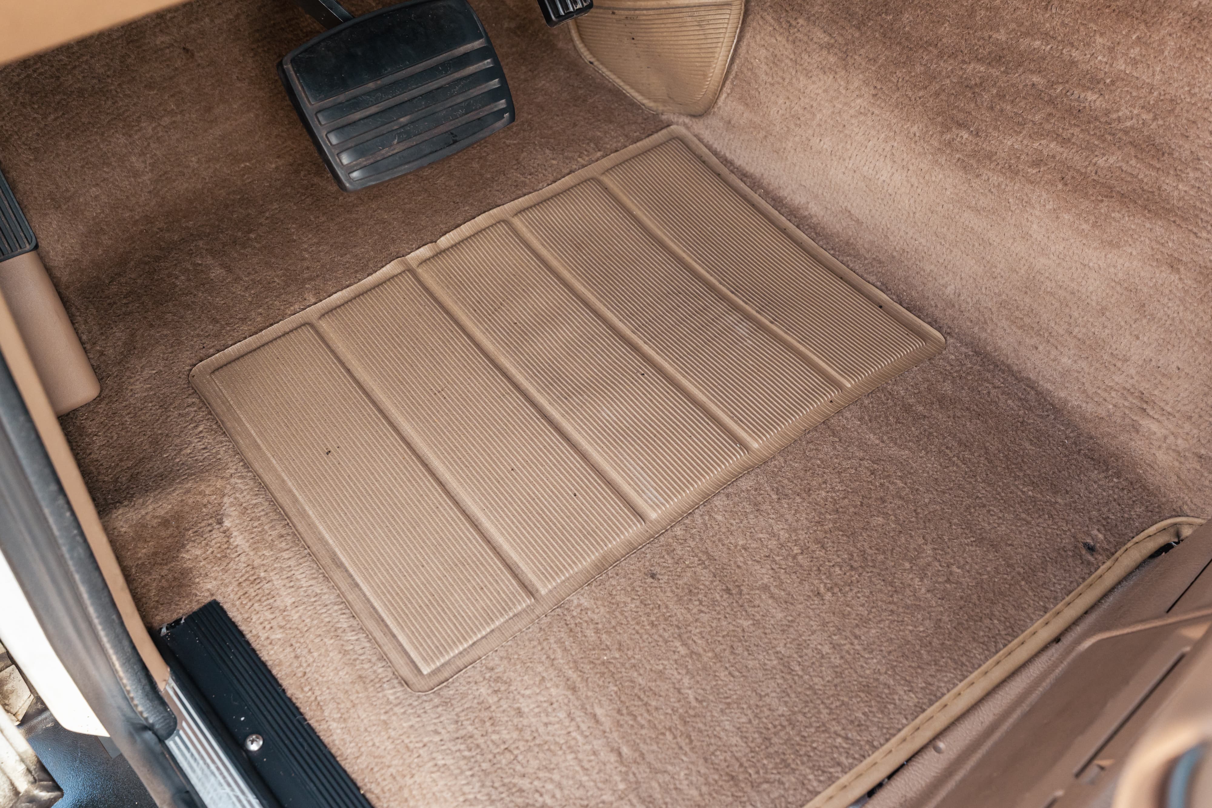 Tan carpet floor mat and pedals in a 1995 Range Rover County.