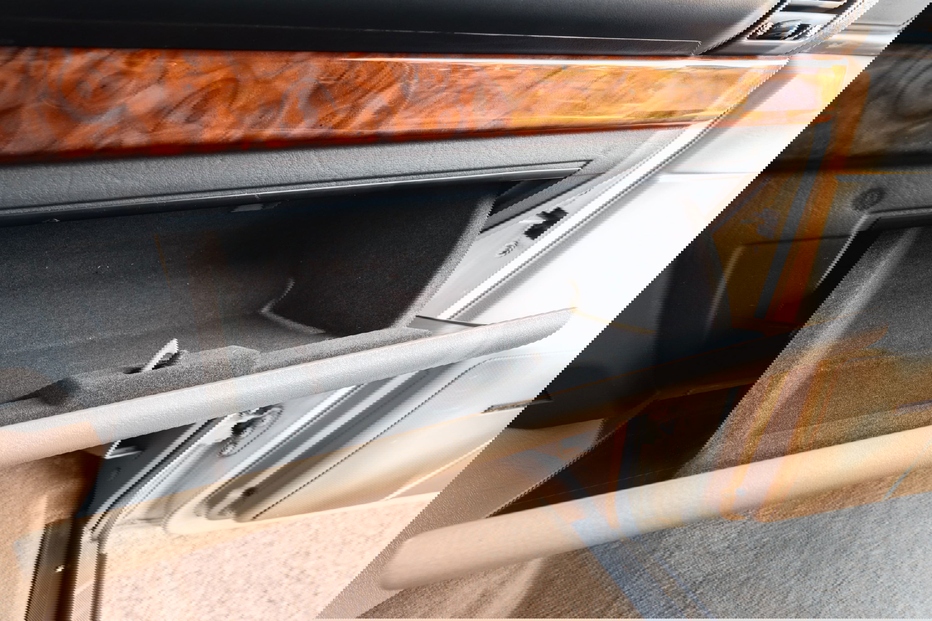 1995 Range Rover County open glove box with wood trim and beige interior.