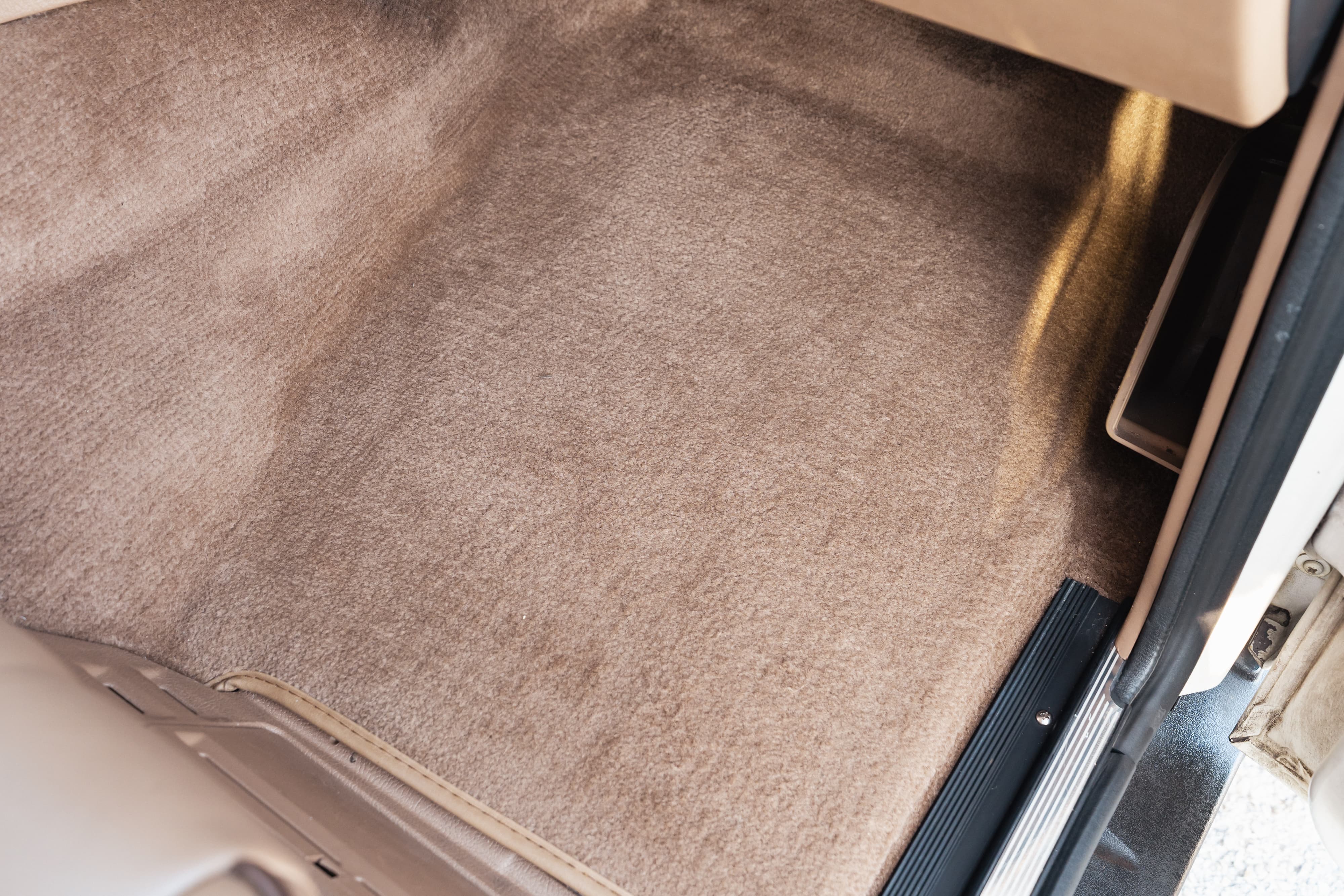 Tan carpet and trim on the floor of a white 1995 Land Rover Range Rover County.