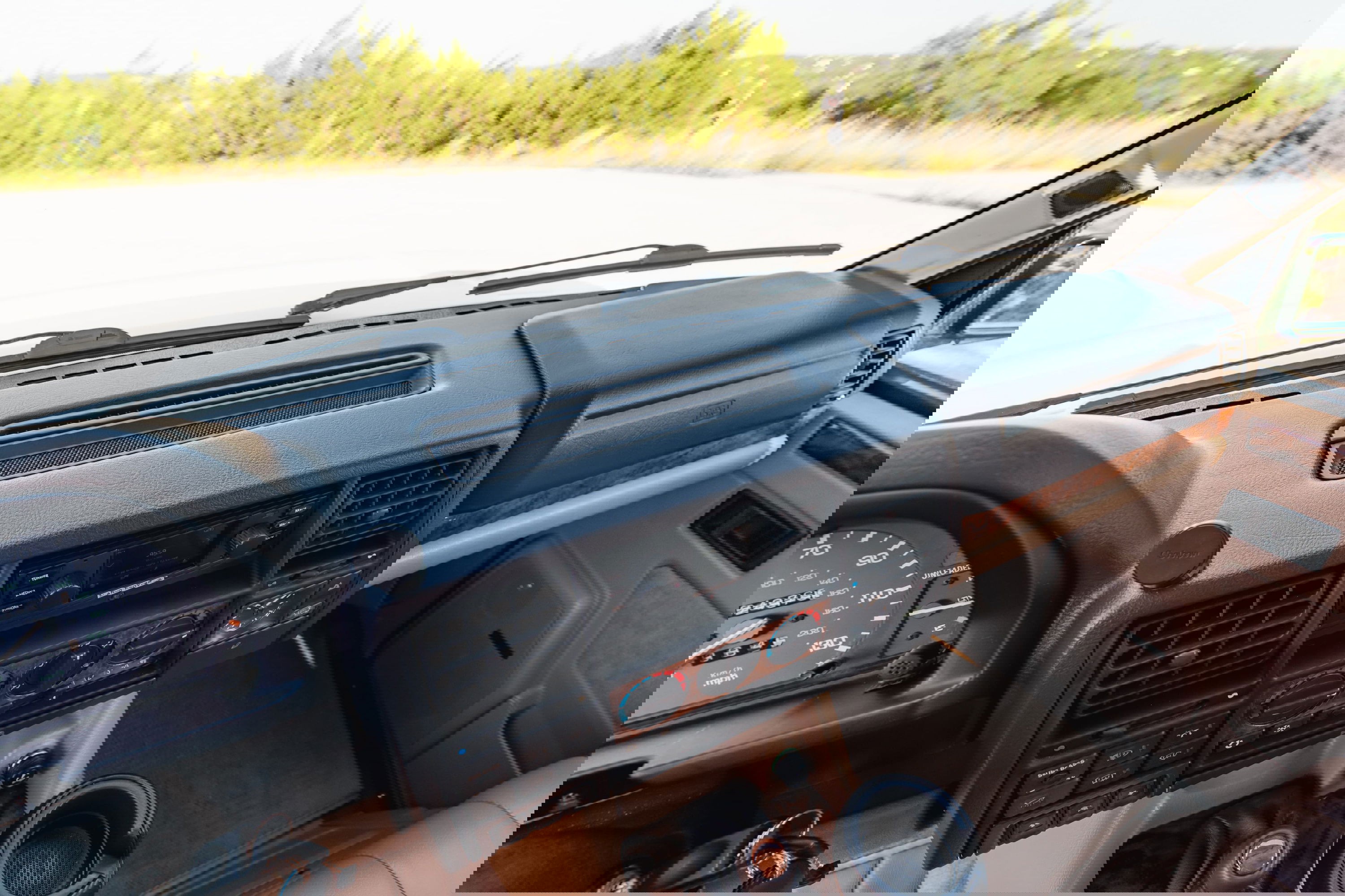 Interior dashboard of a white 1995 Land Rover Range Rover County with wood trim and tan upholstery.