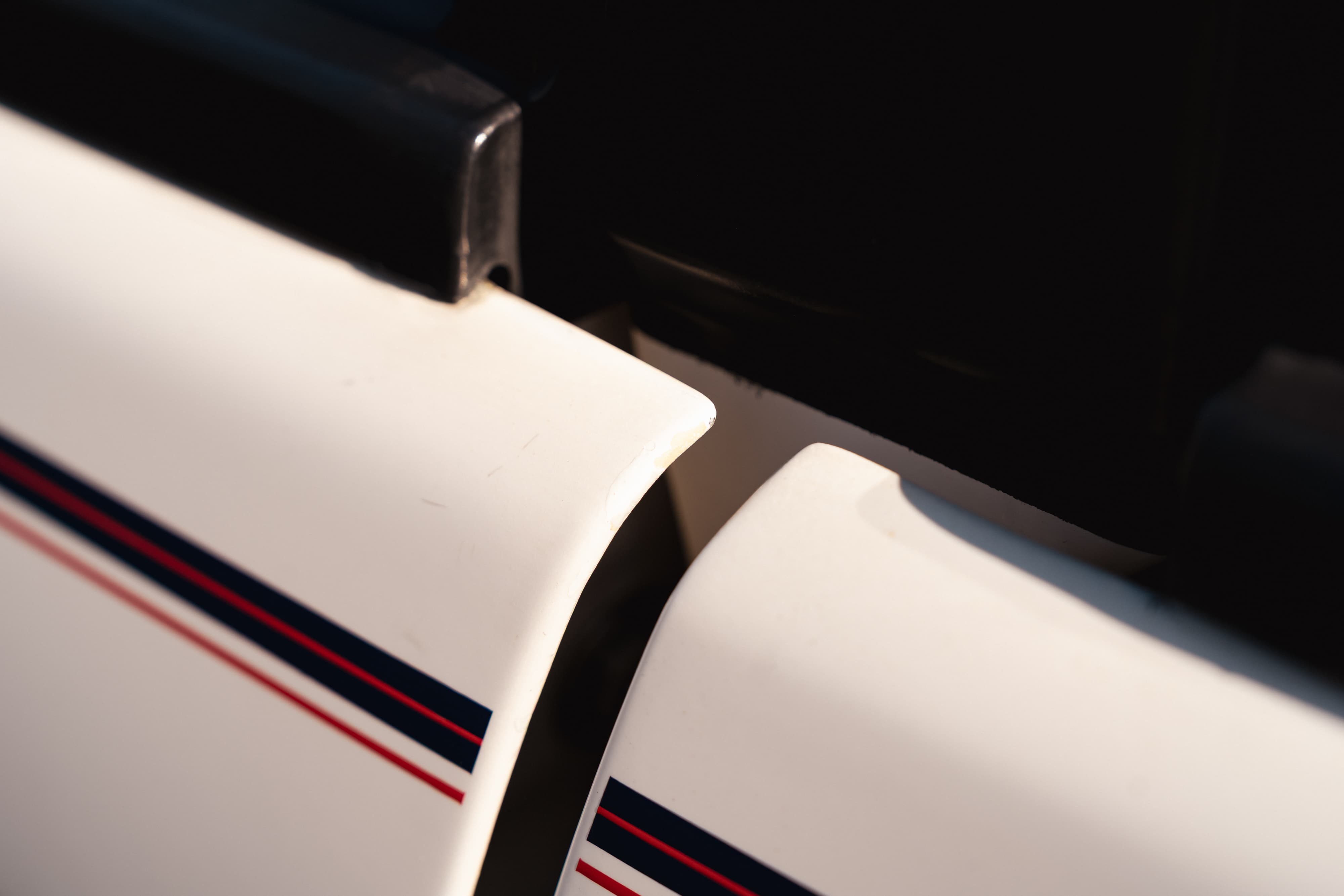 Close-up of a white 1995 Range Rover County with racing stripes on the door trim.