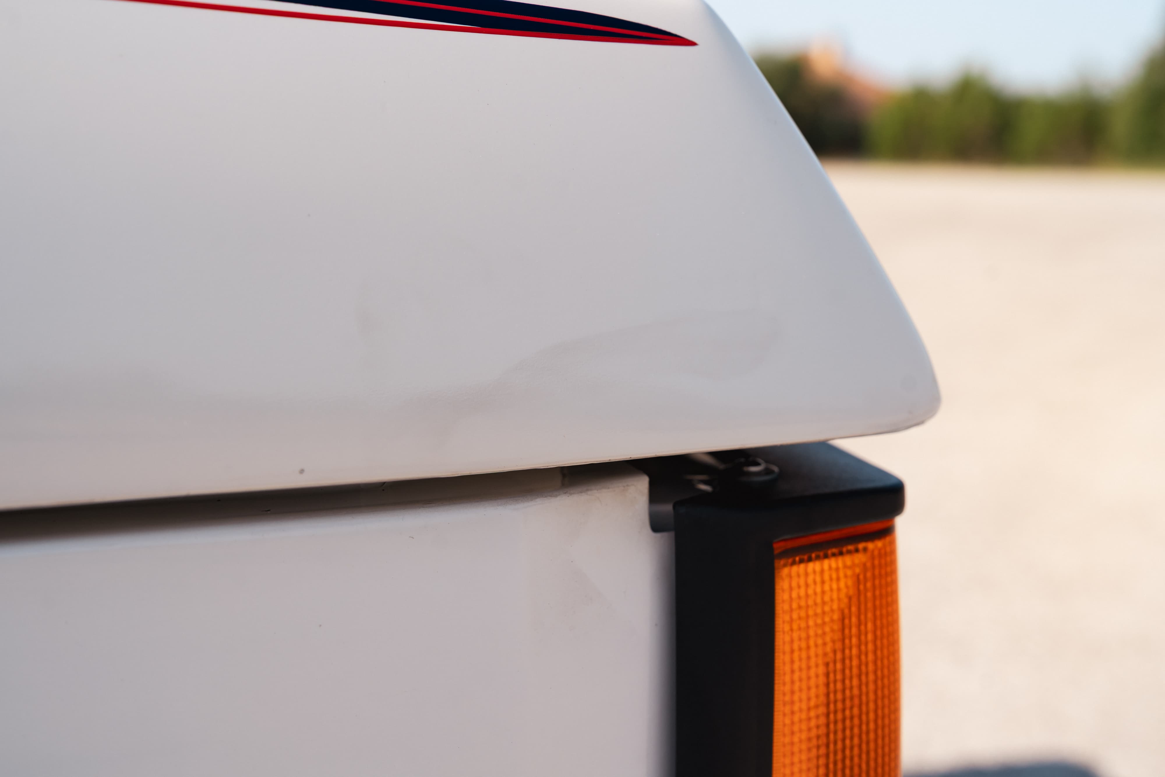 White 1995 Range Rover County with red & blue stripe livery detail and amber marker light.