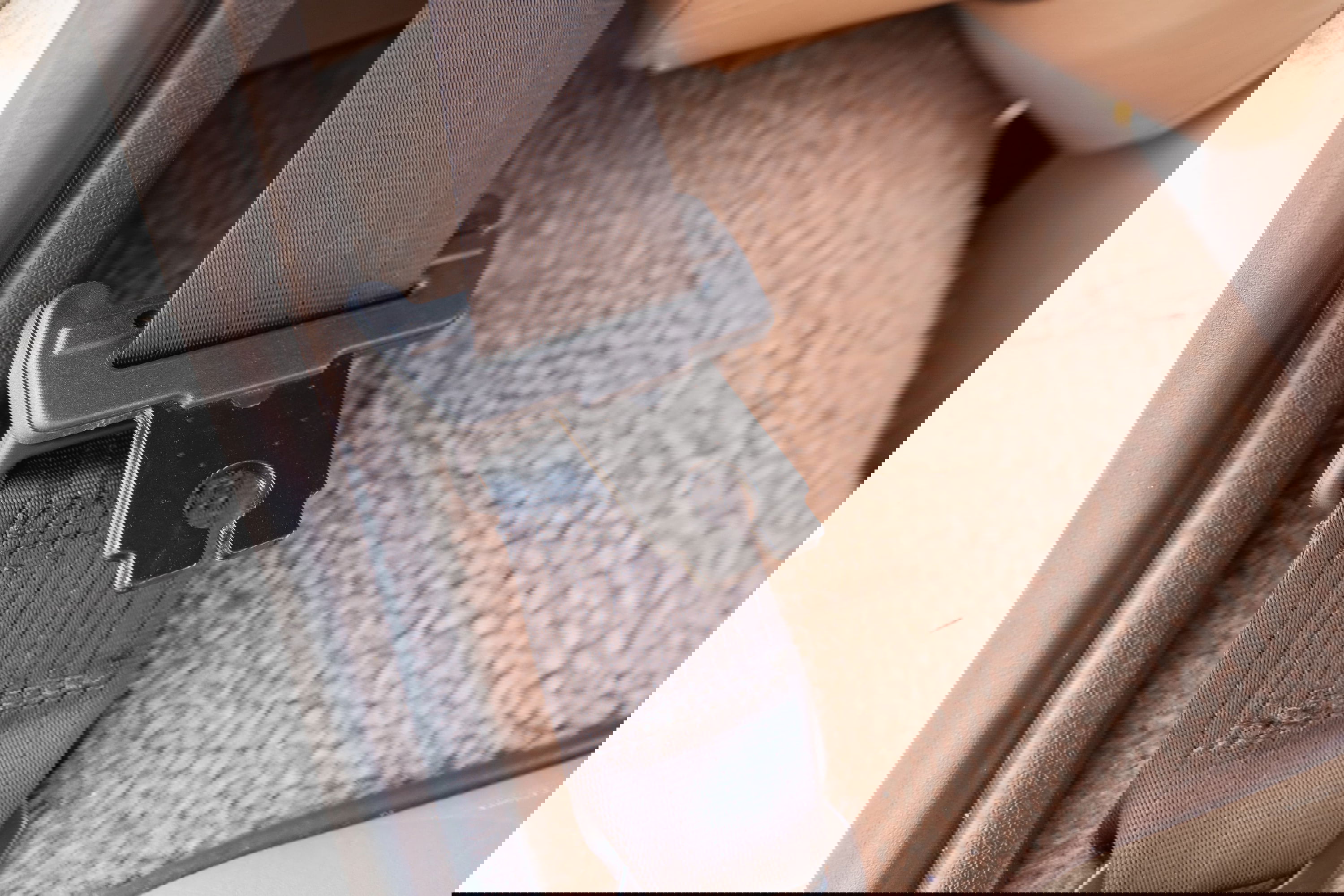 1995 white Land Rover Range Rover County seatbelt buckle and tan carpet.