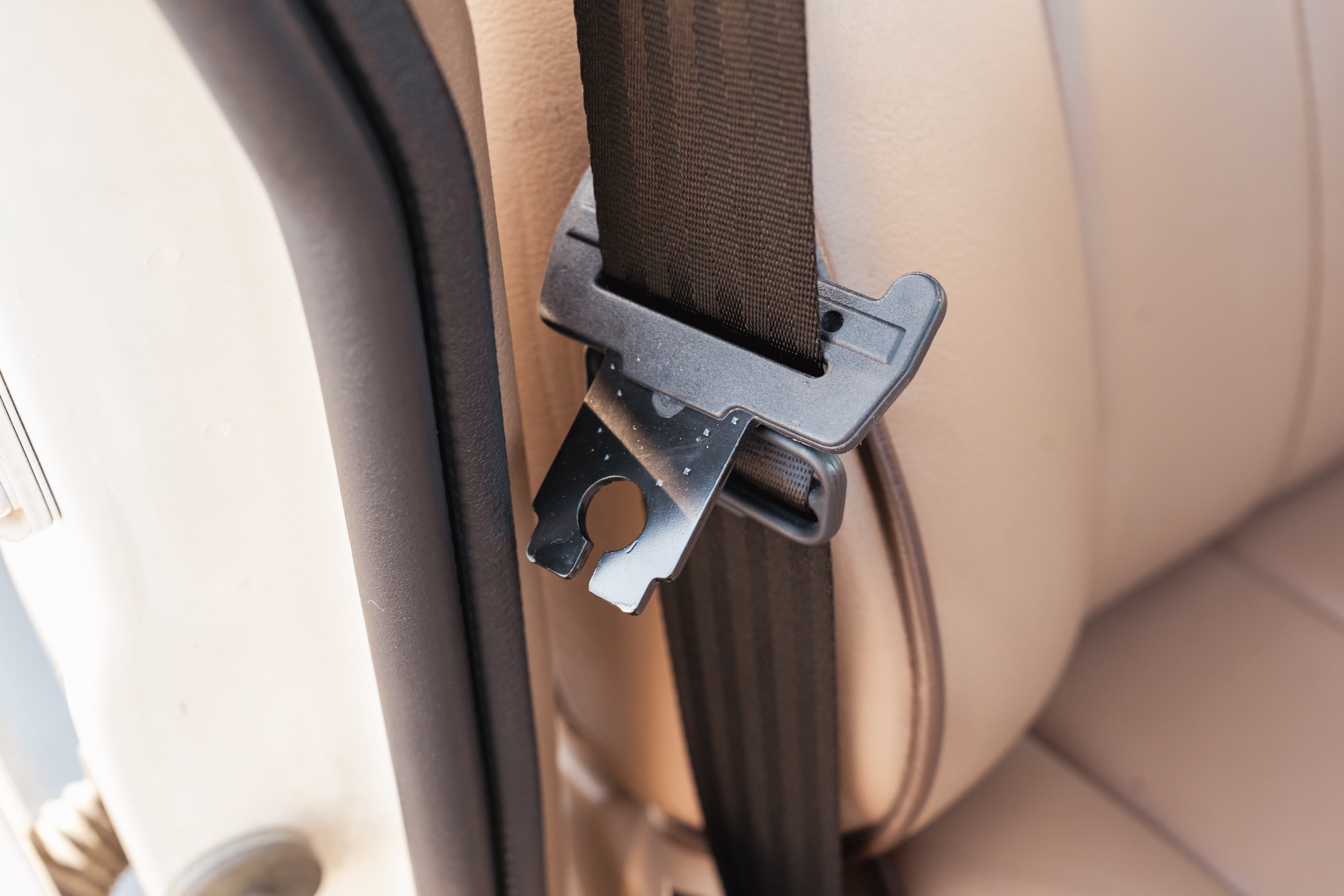 Close-up of the seatbelt mechanism inside a white 1995 Land Rover Range Rover County.