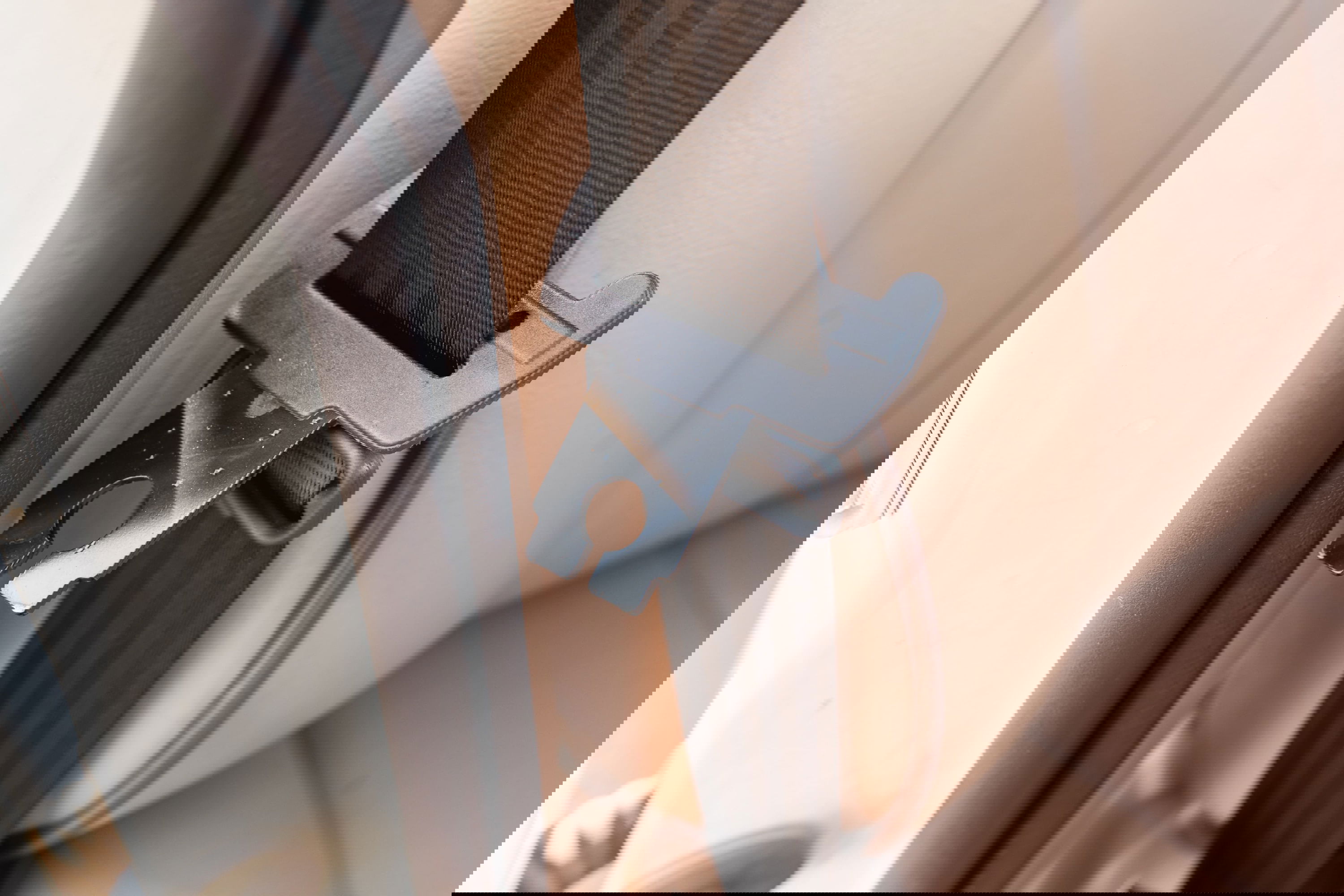 Close-up of the seatbelt mechanism inside a white 1995 Land Rover Range Rover County.