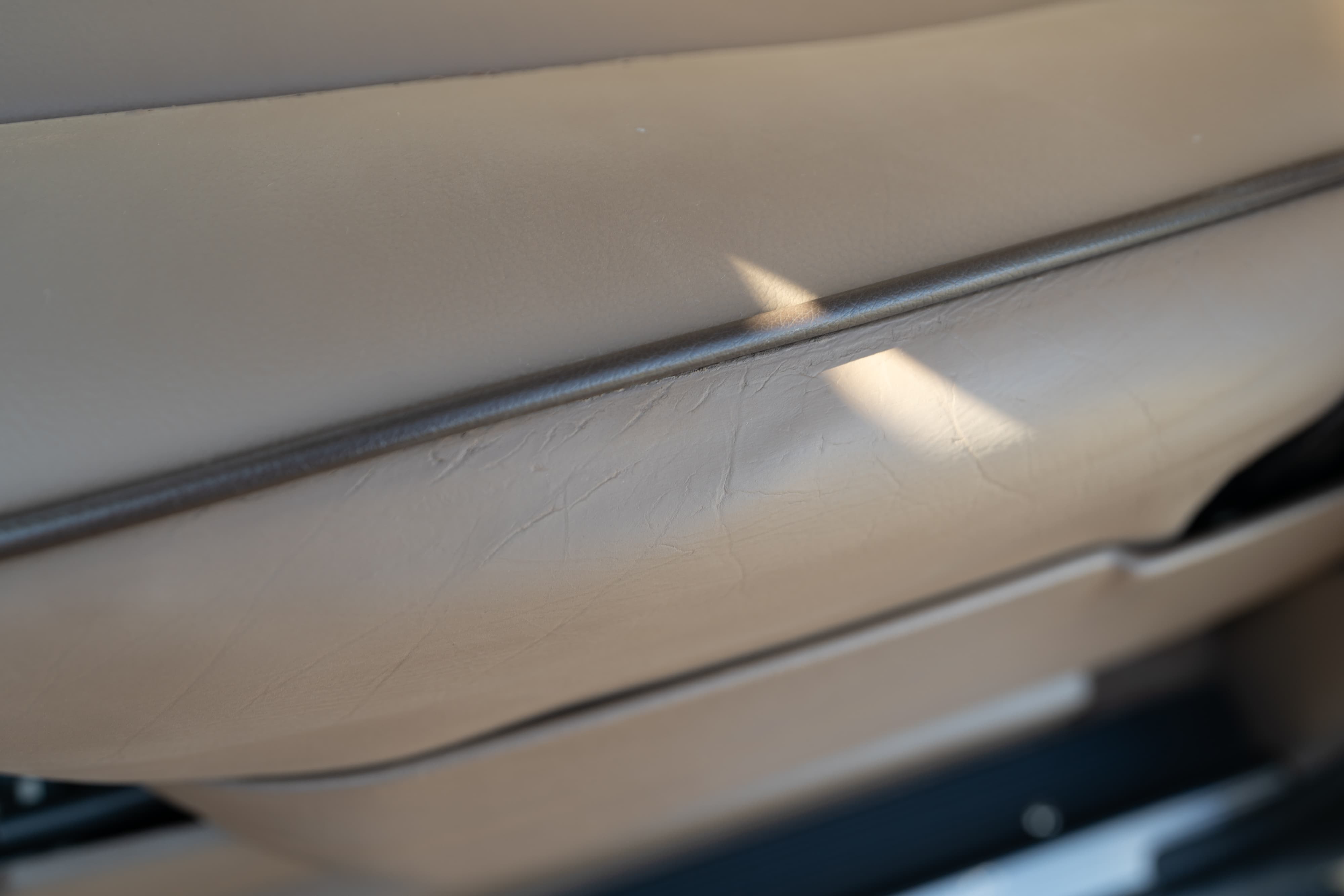 Tan interior trim detail on a 1995 Range Rover County, showing subtle texture and sunlight highlights.