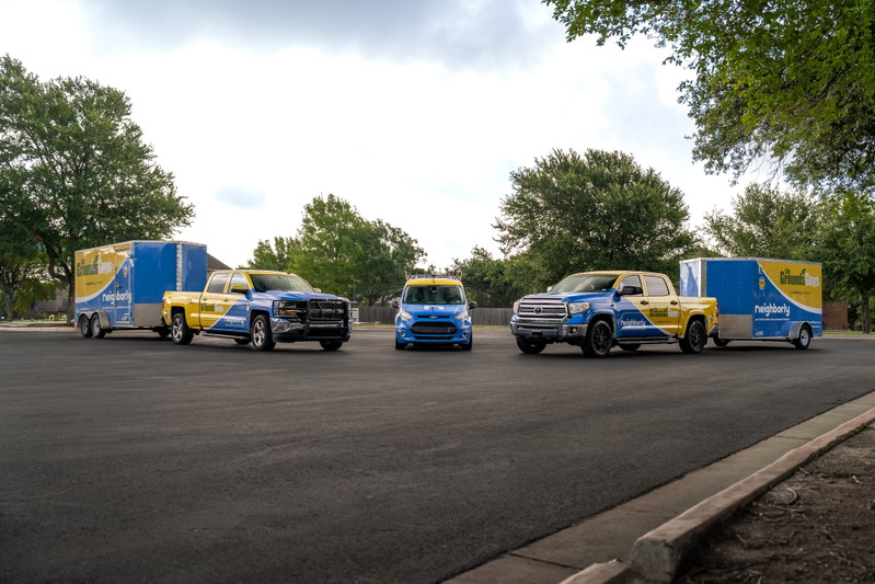Two Chevrolet Silverado pickup trucks and a blue van with custom yellow and blue livery.