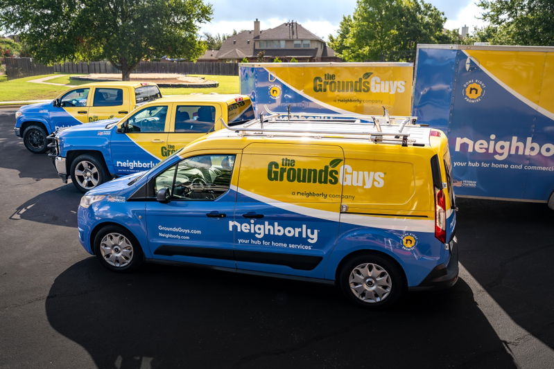 A blue and yellow Ford Transit Connect van with Neighborly livery, featuring silver rims.