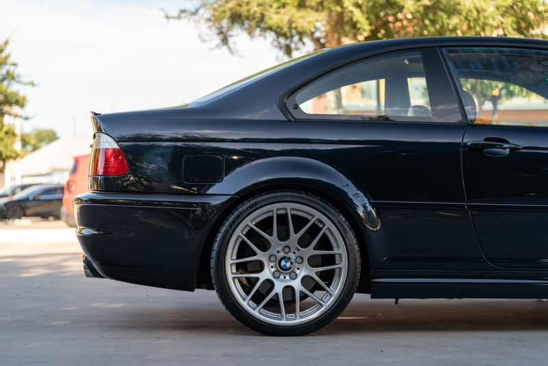 Rear quarter view of a black 2002 BMW M3 coupe, featuring M-Parallel rims.