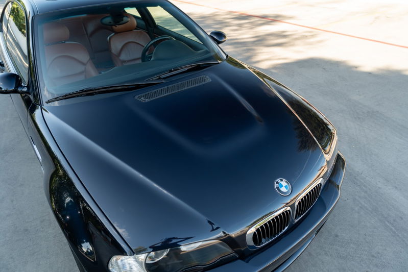 Carbon Black 2002 BMW M3 coupe with tan leather interior, hood scoop, and chrome grille.