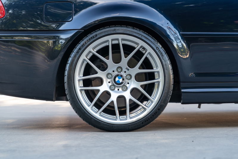 Detail of a dark blue 2002 BMW M3 rear wheel and tire.