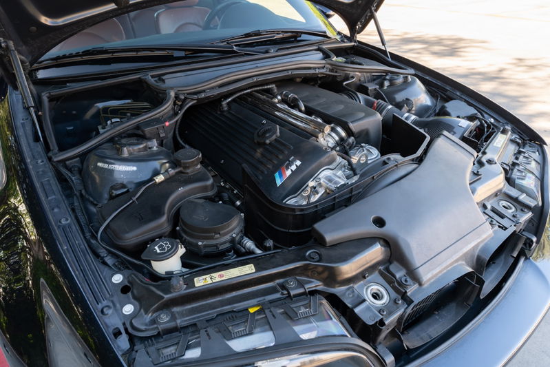 2002 BMW M3 in Carbon Black, showing the engine bay and M-power V8 engine.