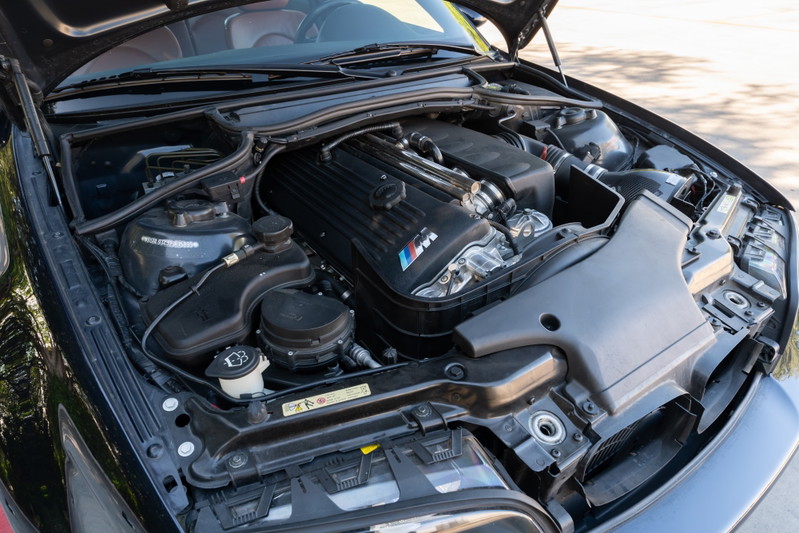 2002 BMW M3 in Carbon Black, showing the engine bay and M-power V8 engine.