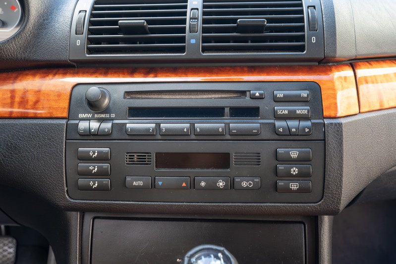 Interior of a 2002 BMW M3 with wood trim and BMW Business CD stereo.