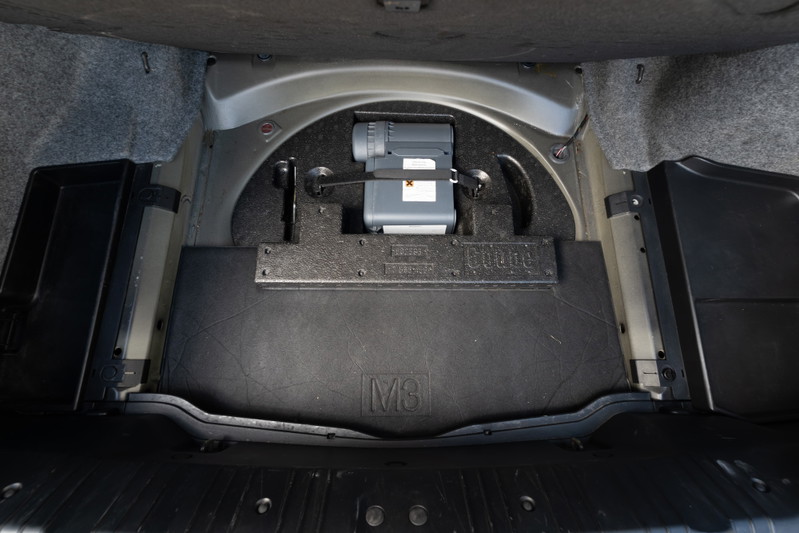 2002 BMW M3 trunk features a compact spare tire kit and M logo trim.